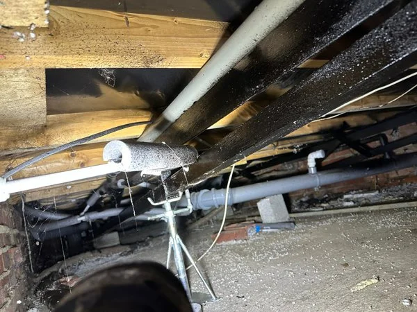 View of plumbing and electrical pipes under a park home
