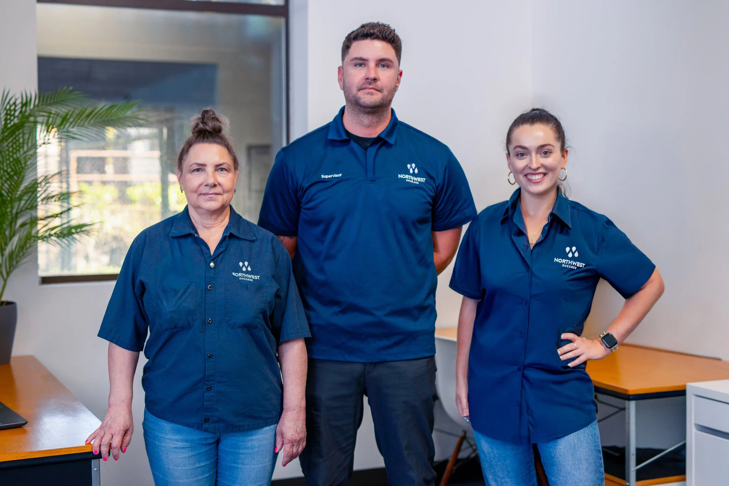 Three Northwest Success janitors looking at the camera