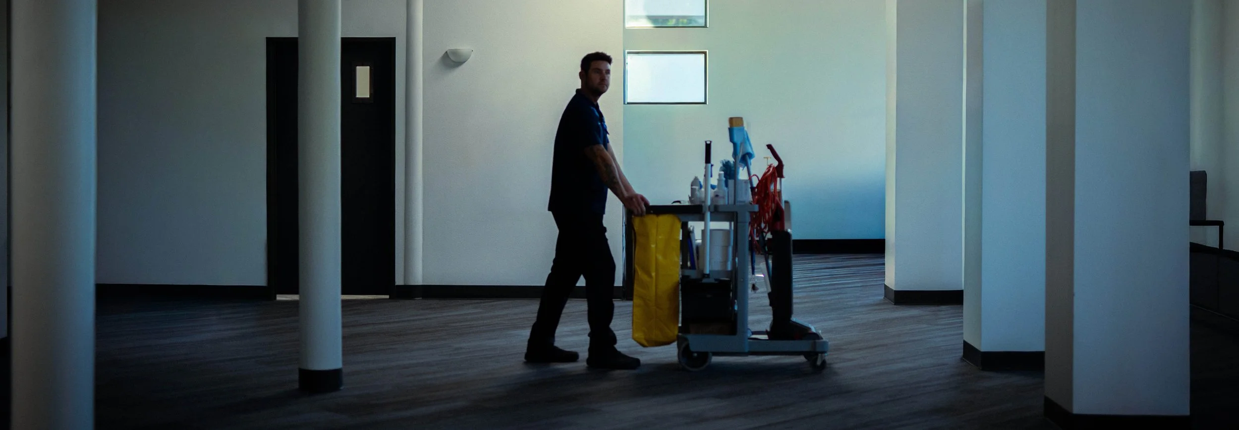 Northwest Success janitor pushing cart through empty office