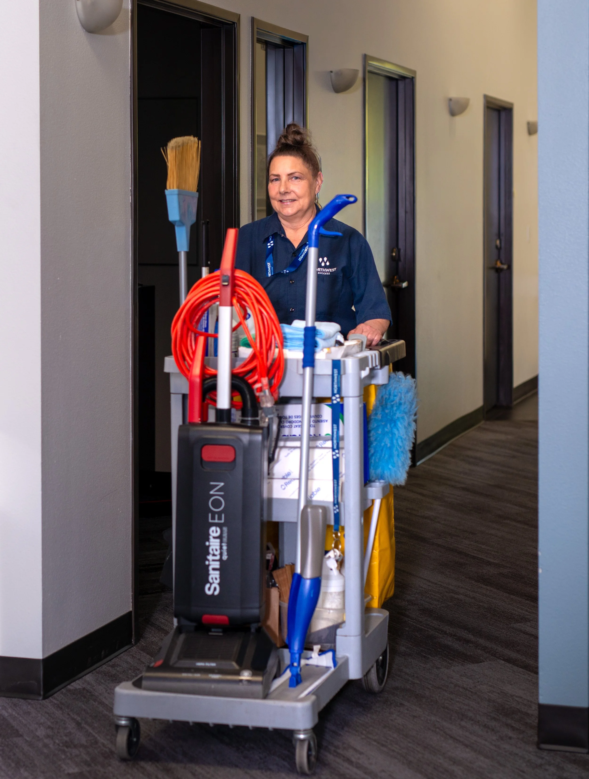 Northwest Success janitor pushing cleaning cart