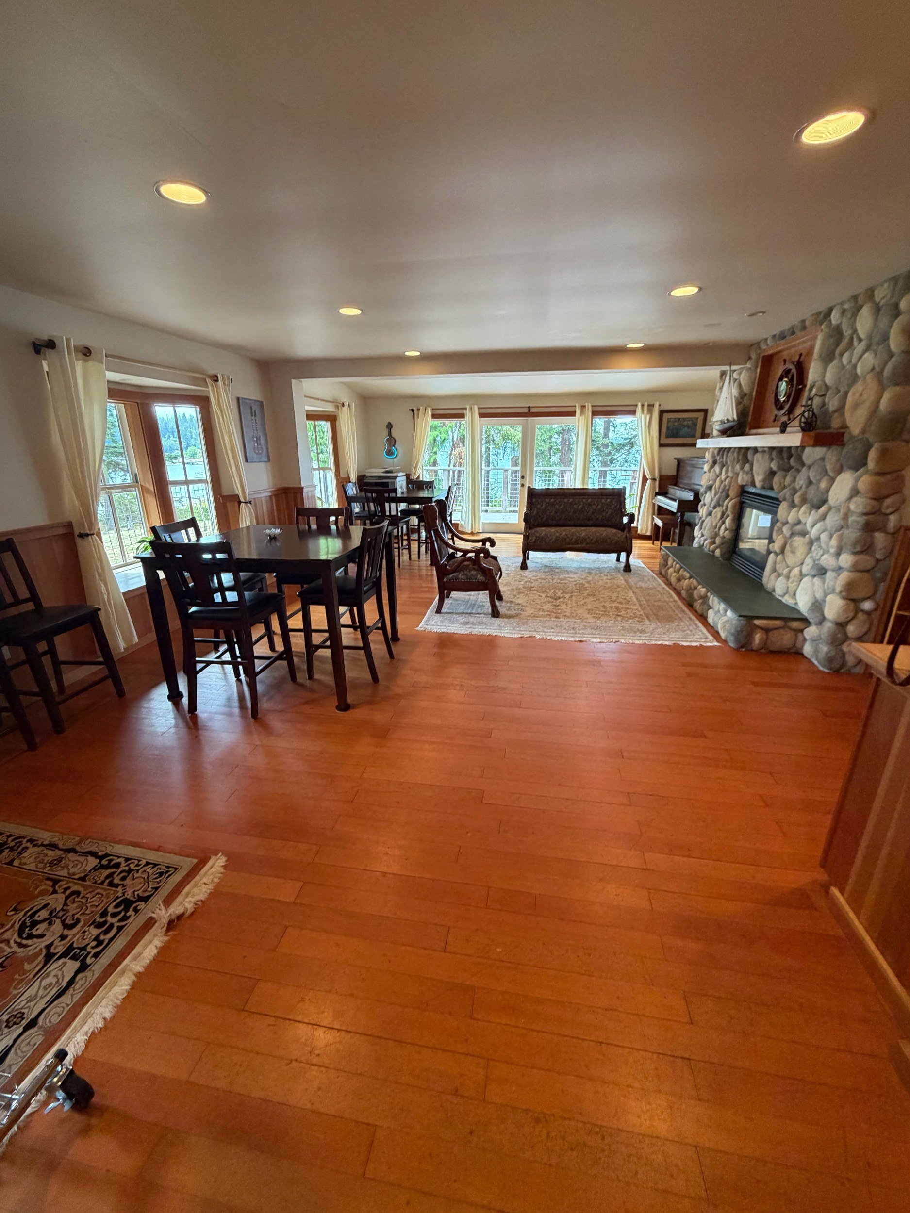Downstairs room with river-rock fireplace and harbor-view windows