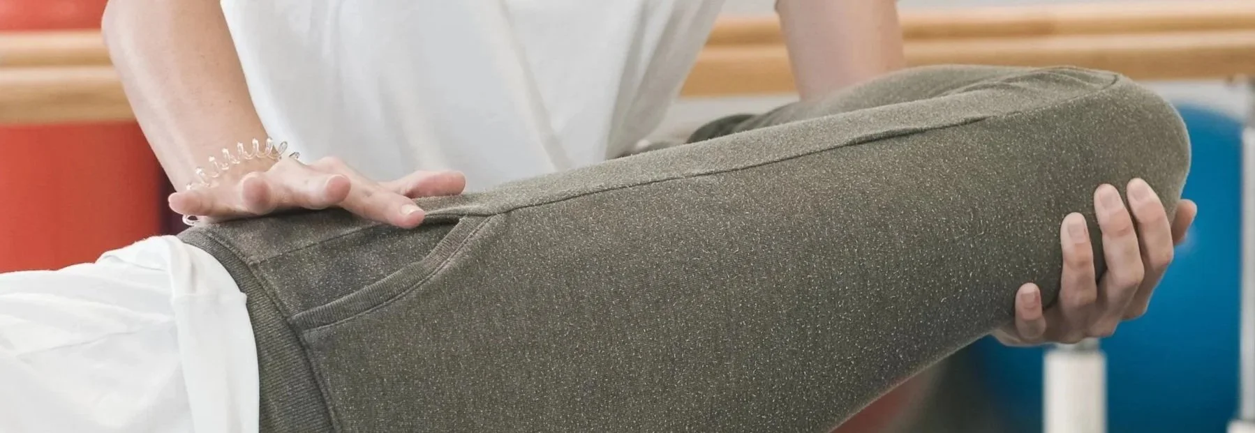Person receiving physical therapy, holding their leg in a stretching or therapeutic position.