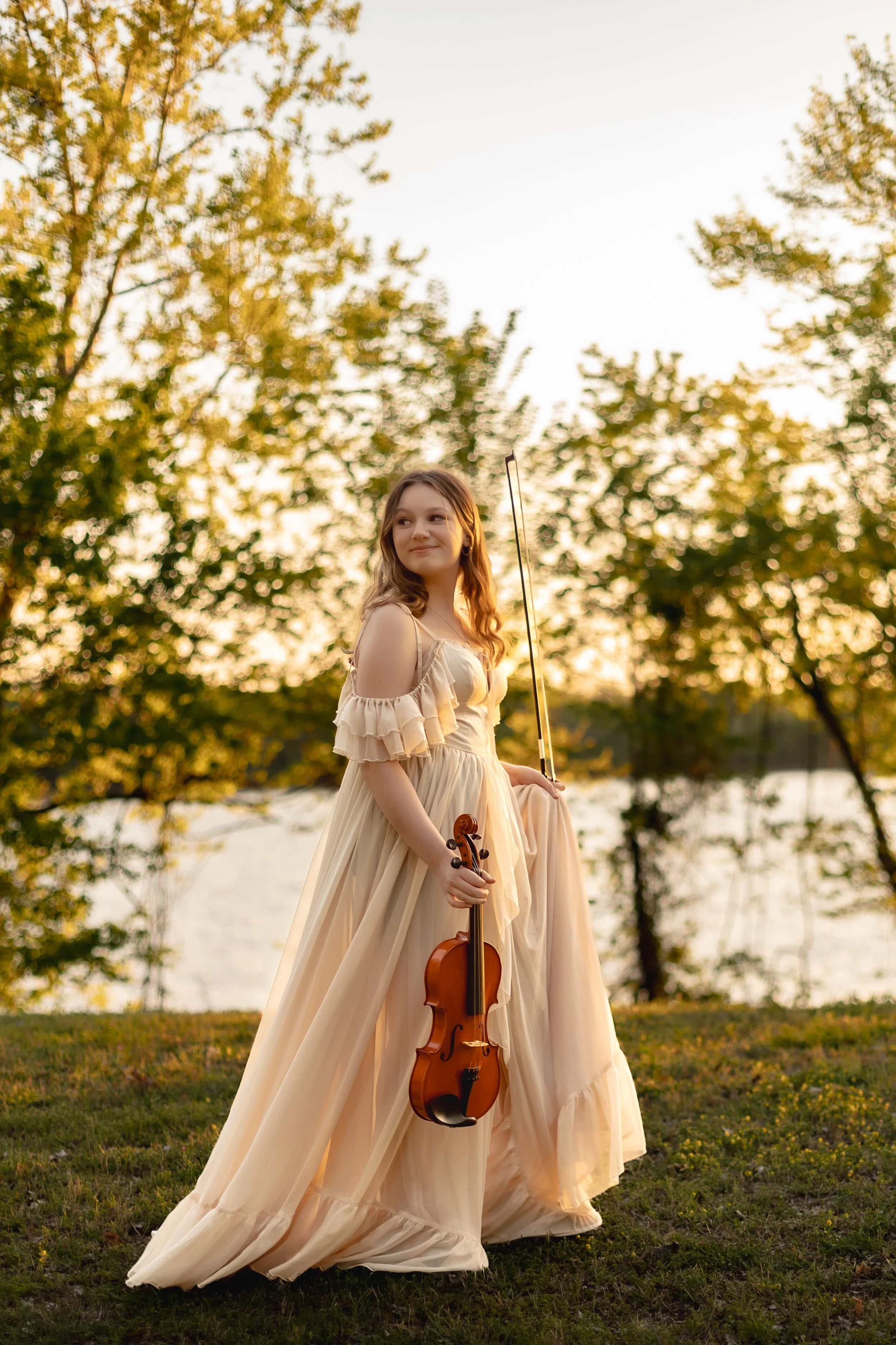 Van Buren, AR Photographer captures a young teens portraits by the Arkansas river in a gown from her client closet.