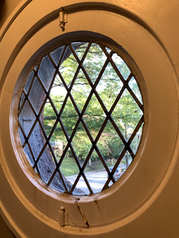 Porthole window significantly damaged by pooling water, and weather.