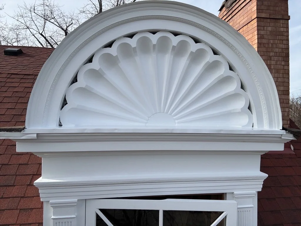 After the original wood was stripped and sanded, various methods were used to fill, rebuild and replace the cracks, pits, and missing pieces of the pediment.  The pieces were finely sanded again, and received one coat of primer and two coats of paint