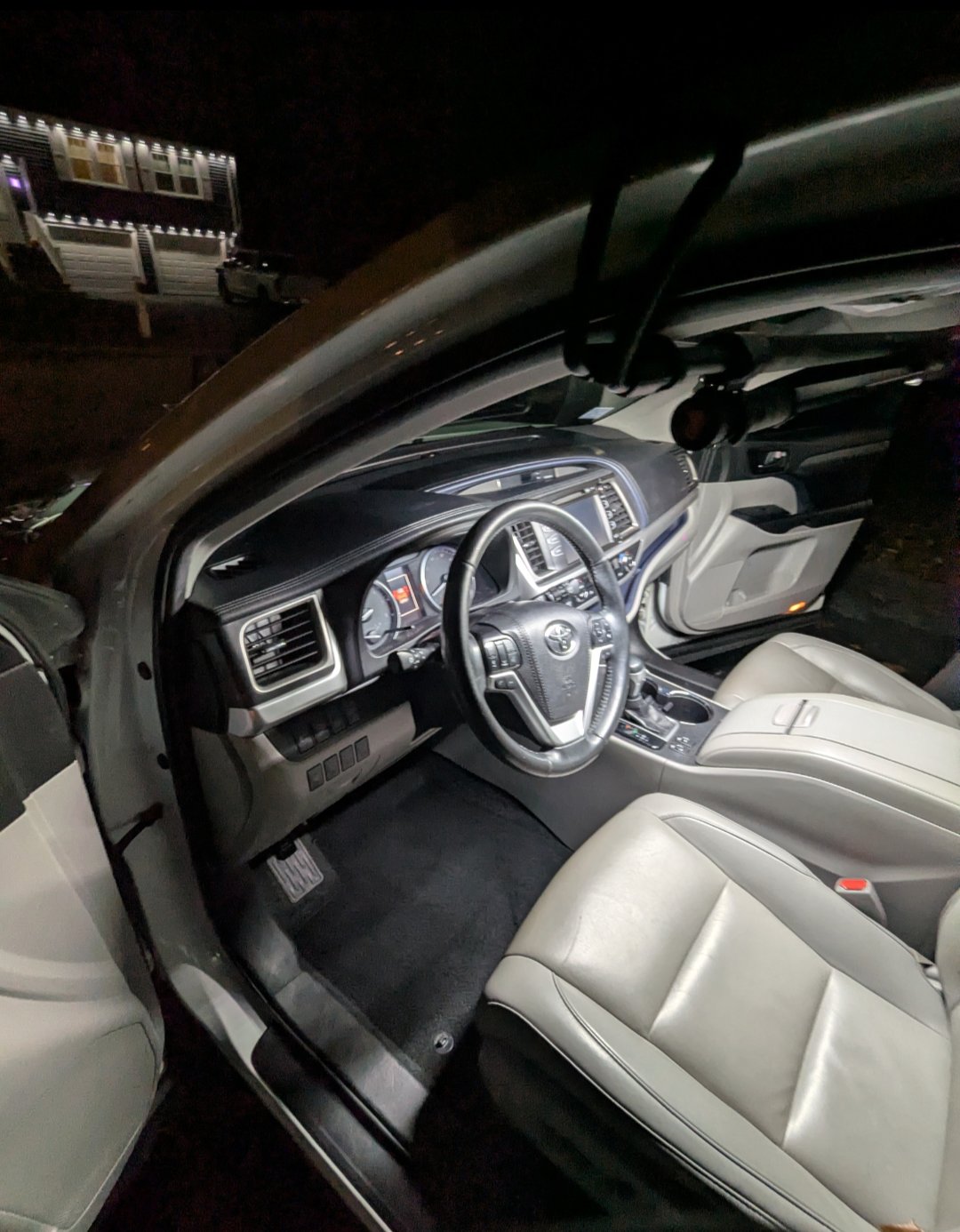 Interior of a car at night, showing the dashboard, steering wheel, and front seats.
