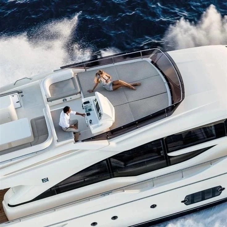 People relaxing on the deck of a yacht sailing on the ocean.