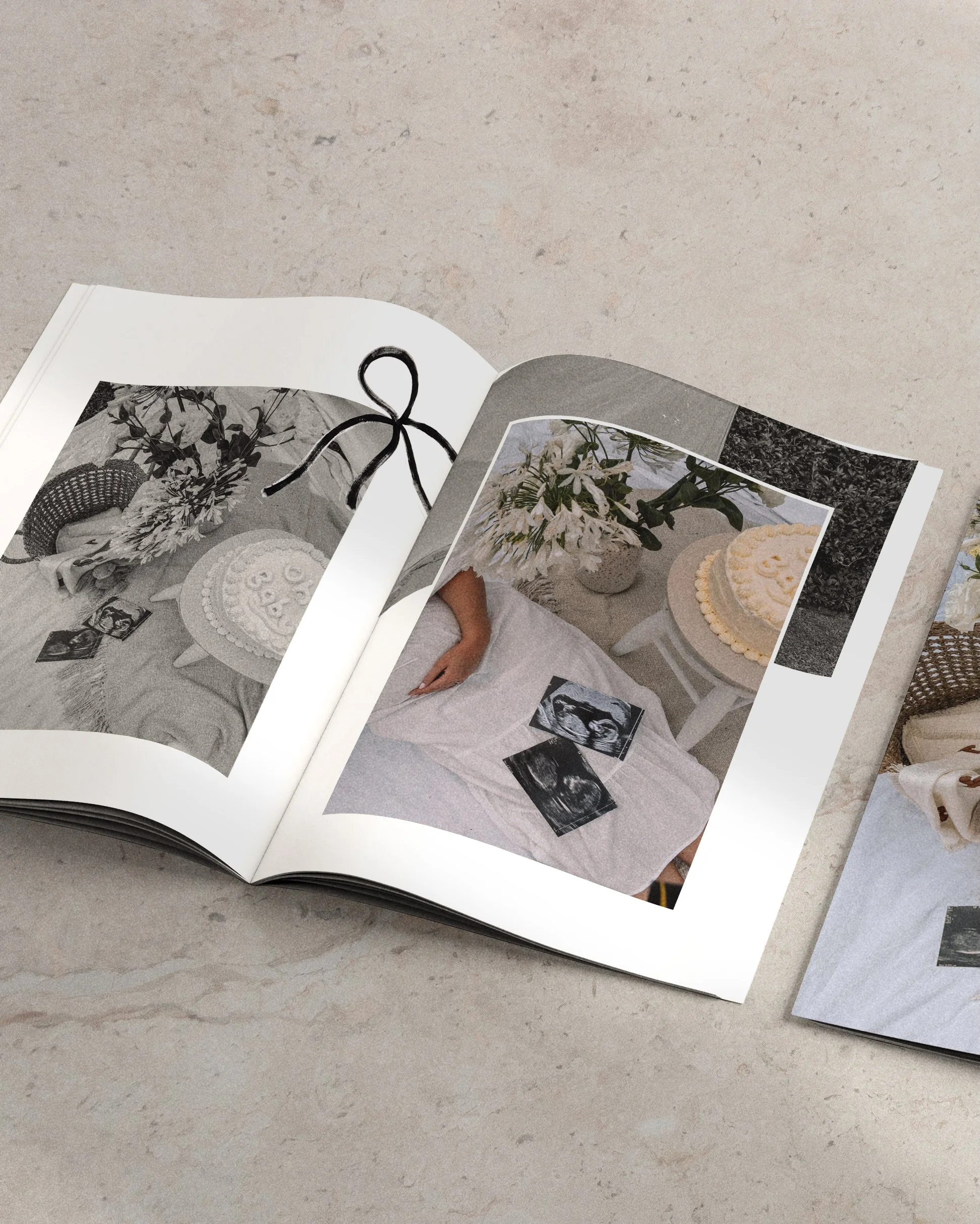 An open magazine displaying a photograph of a white bed with a person lying under a white sheet, next to a white side table with a bouquet of white flowers and a white cake with yellow frosting.