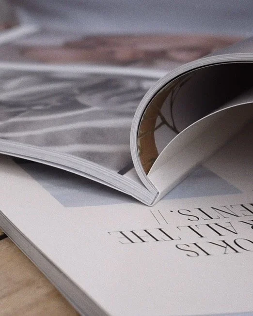 Close-up of an open magazine with pages turned, lying on a surface.