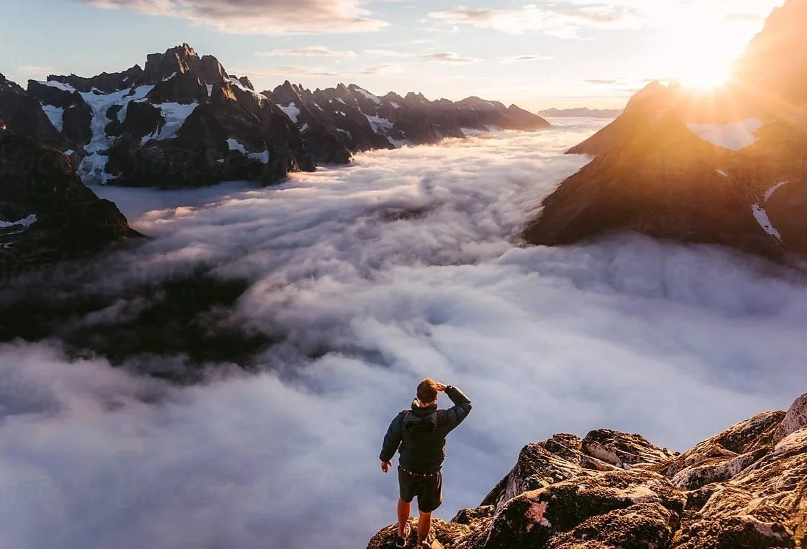 Man standing above cloud-covered mountains symbolizing clear insight and risk evaluation in Ordinance’s captive feasibility studies.