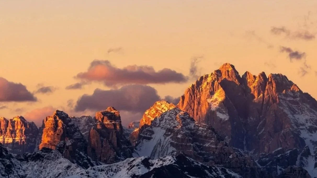 Mountain range illuminated at sunset, symbolizing long-term perspective and strategic actuarial analysis.