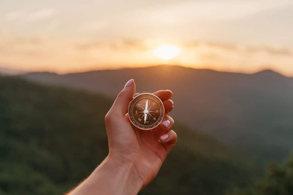 Compass held toward the horizon, symbolizing guidance and clear actuarial explanation.