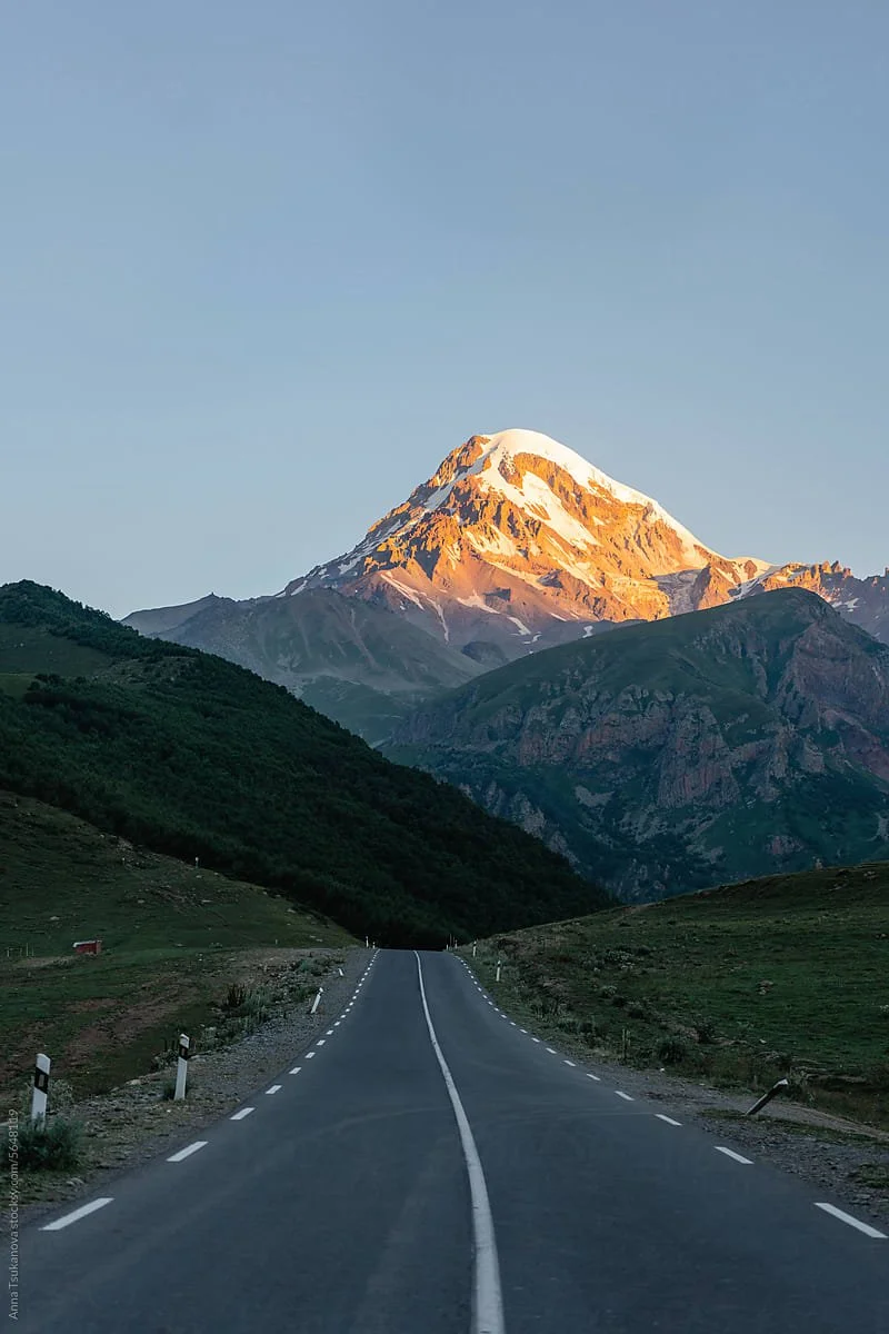 Mountain road at sunrise symbolizing actuarial guidance and clear direction.