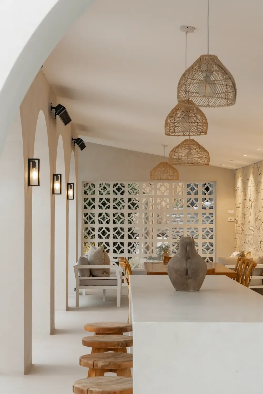 Wabi Sabi outdoor living and dining area with custom microcement table to complement microcement floors, walls, and ceiling perfect for luxury coastal new construction or remodels.