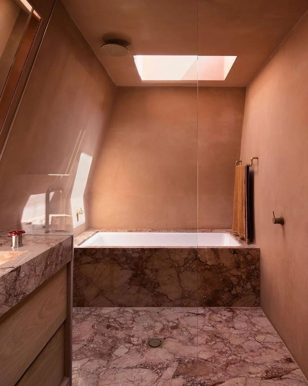 Warm, moody microcement bathroom walls and ceilings to complement a beautiful marble tub and floors.