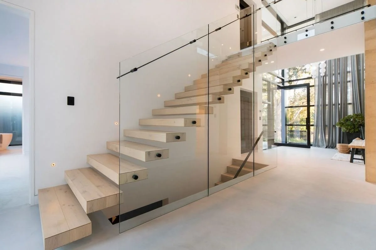 Modern floating staircase complemented by seamless, handcrafted microcement floors 
