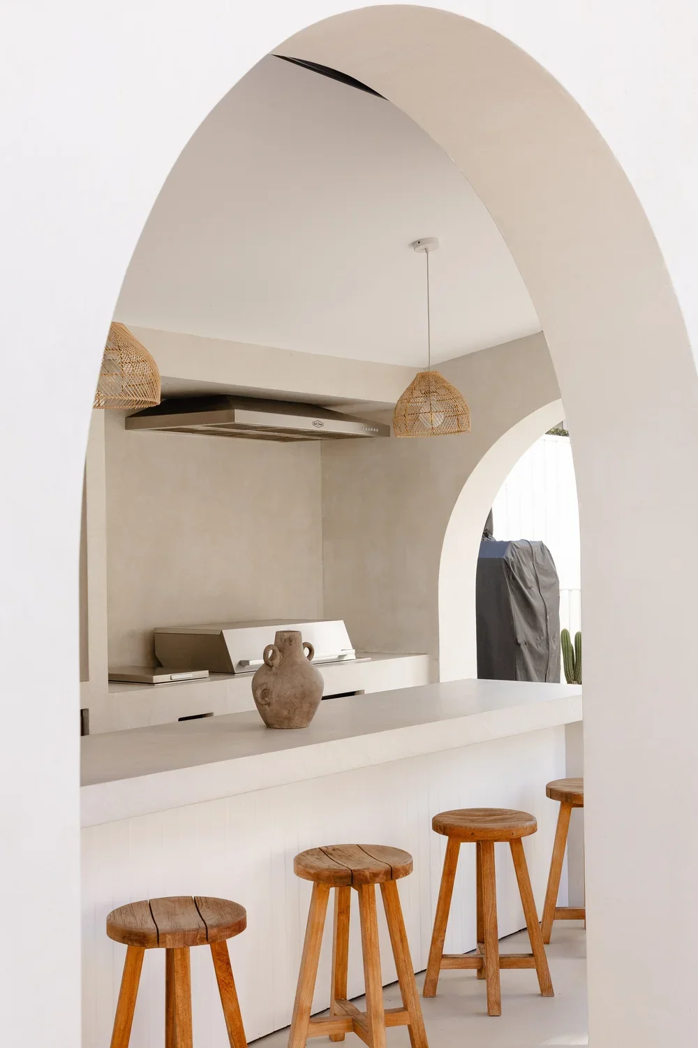 Modern off white microcement outdoor kitchen area including bar and grilling area perfect for Florida, coastal luxury home new construction or remodels.