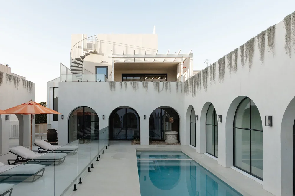 Coastal exterior microcement application including walls, pool deck, and pool