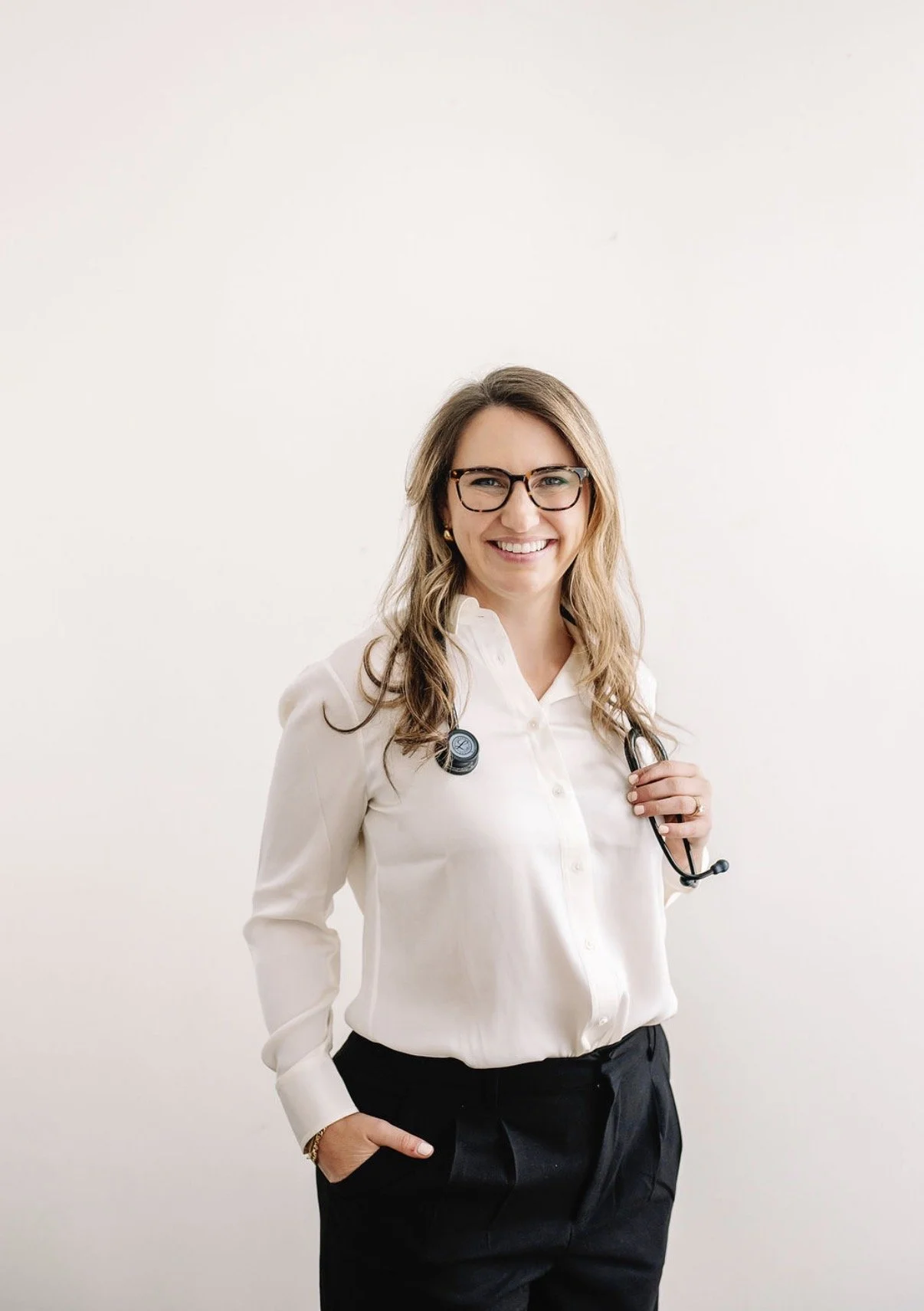 Dr. Warren smiling at camera with stethoscope around neck