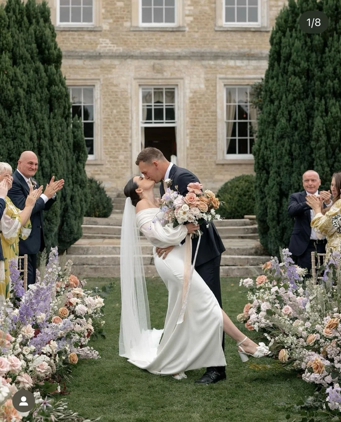 The flowers matter.
But this is the moment everyone remembers.

Soft lilacs, peach garden roses and that just-married kind of joy.