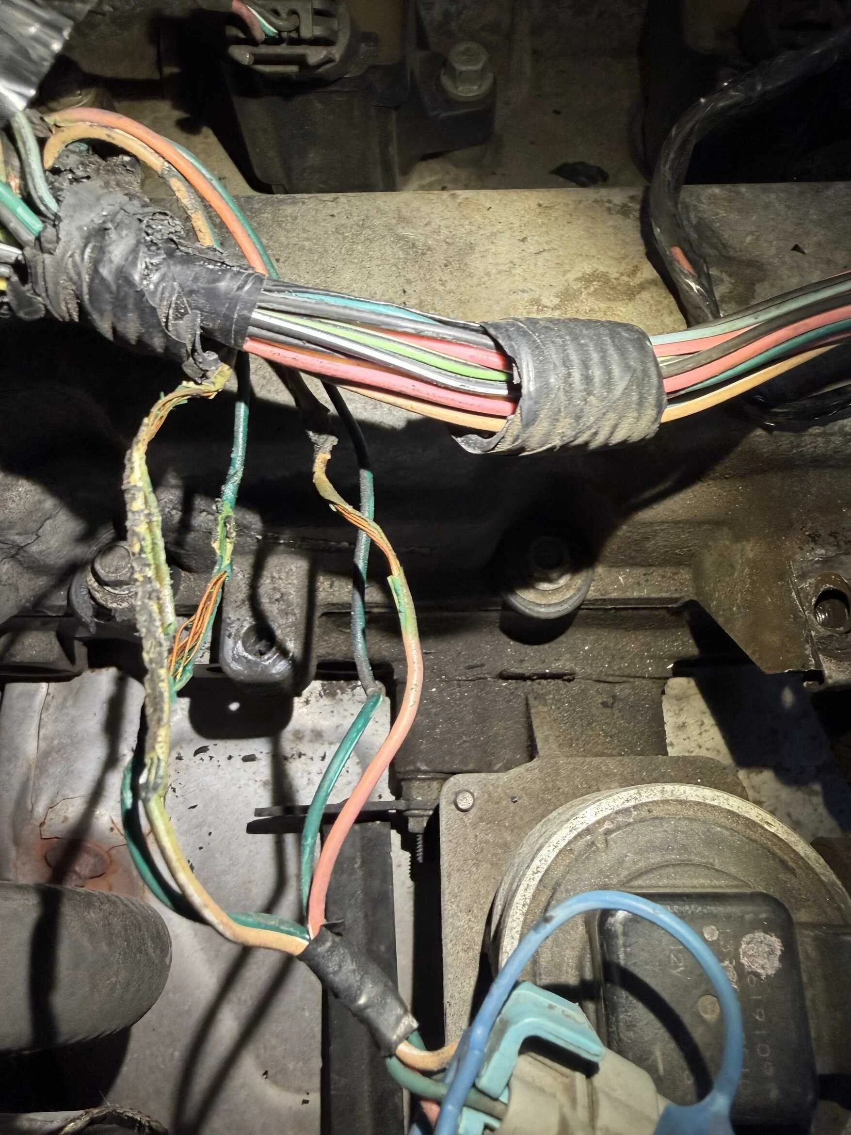 Close-up of electrical wires and components inside an automotive or machinery panel, showing insulated color-coded wires and connectors.