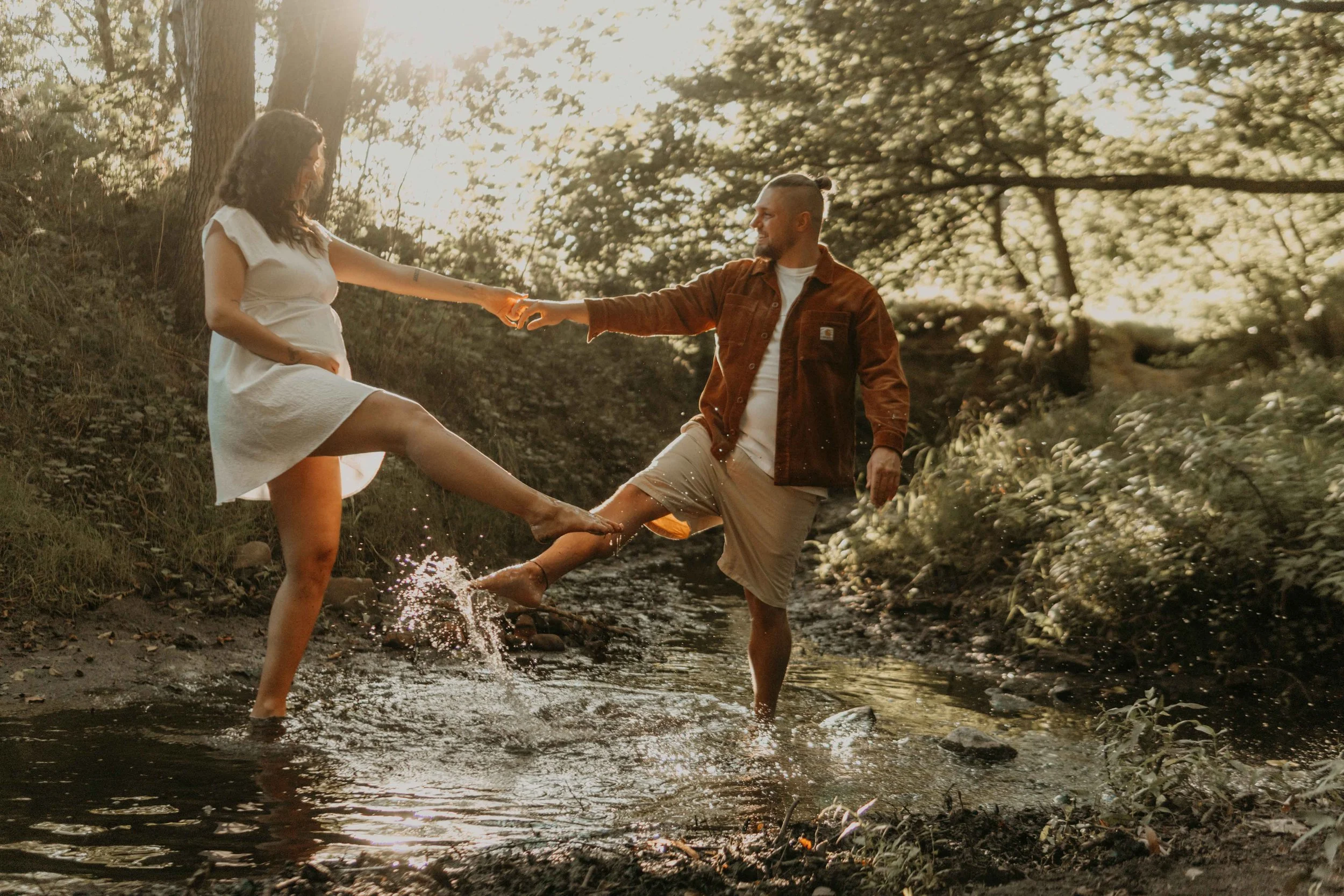 Maternety Shooting Hamburg – werdende Eltern toben im Bach mit dem Wasser. 