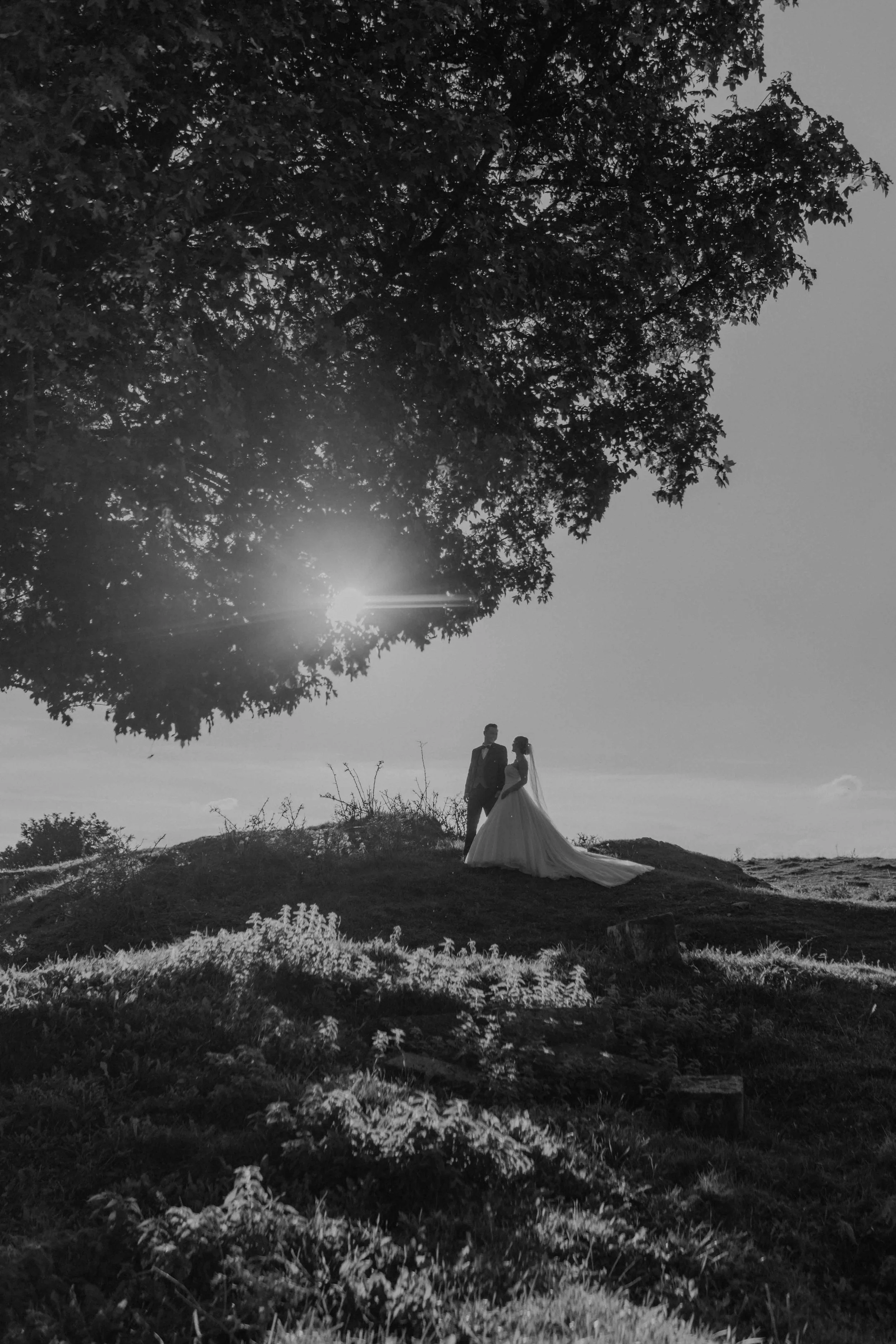 Hochzeitsreportage Hessen – Braut und Bräutigam laufen Hand in Hand über ein Feld.