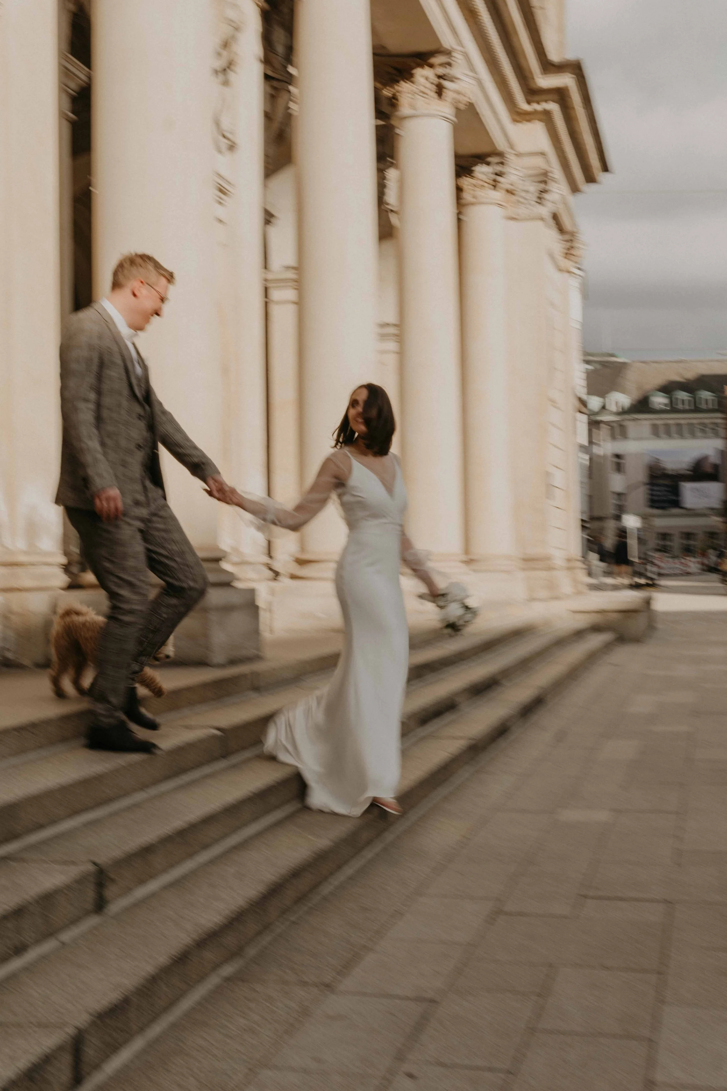 After Wedding Fotos Hamburg – Paar tanzt auf den Stufen des Rathauses, elegant & modern.