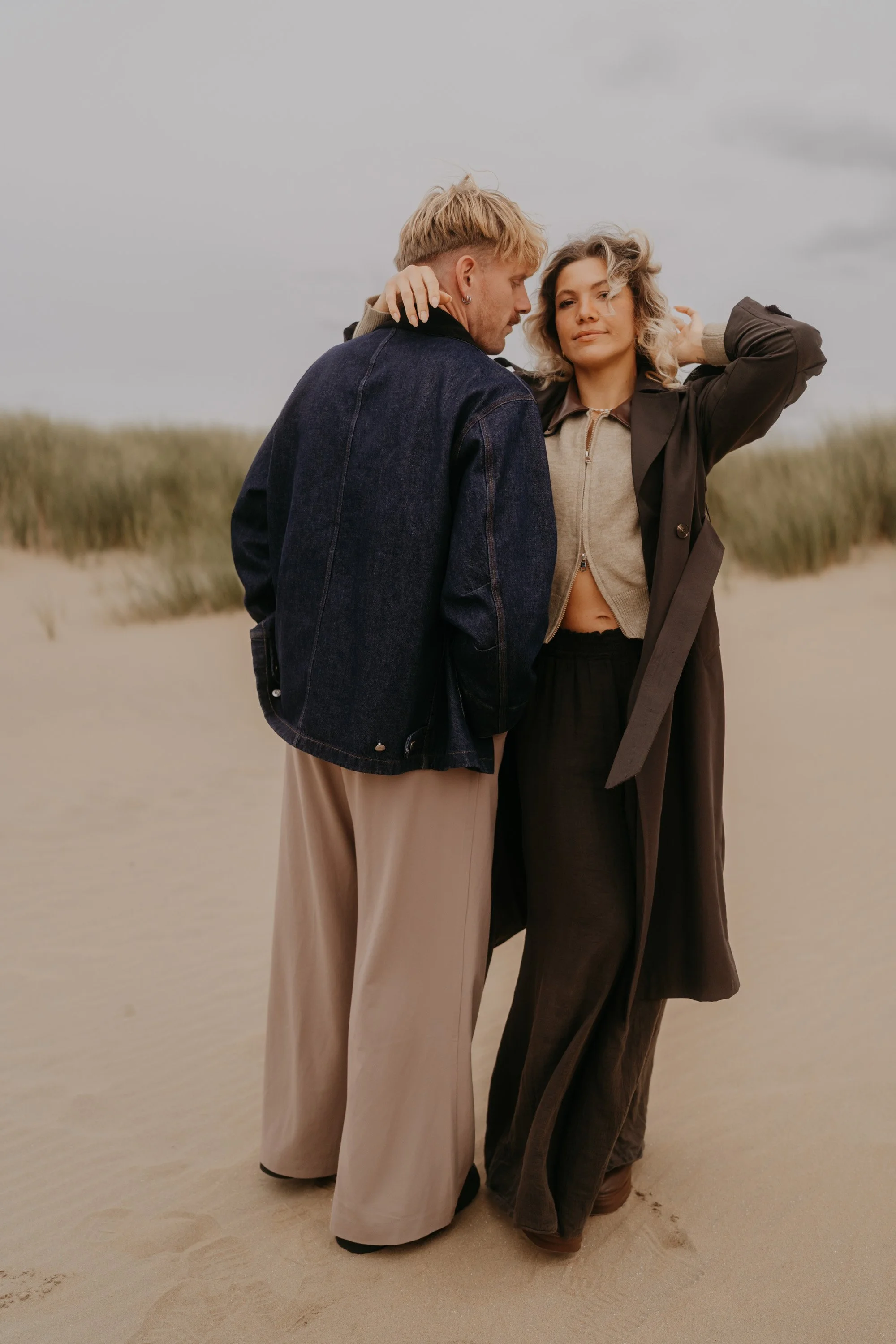 Natürliche Paarfotos Zandvoort – Lachen, Umarmung und Wind im Haar.