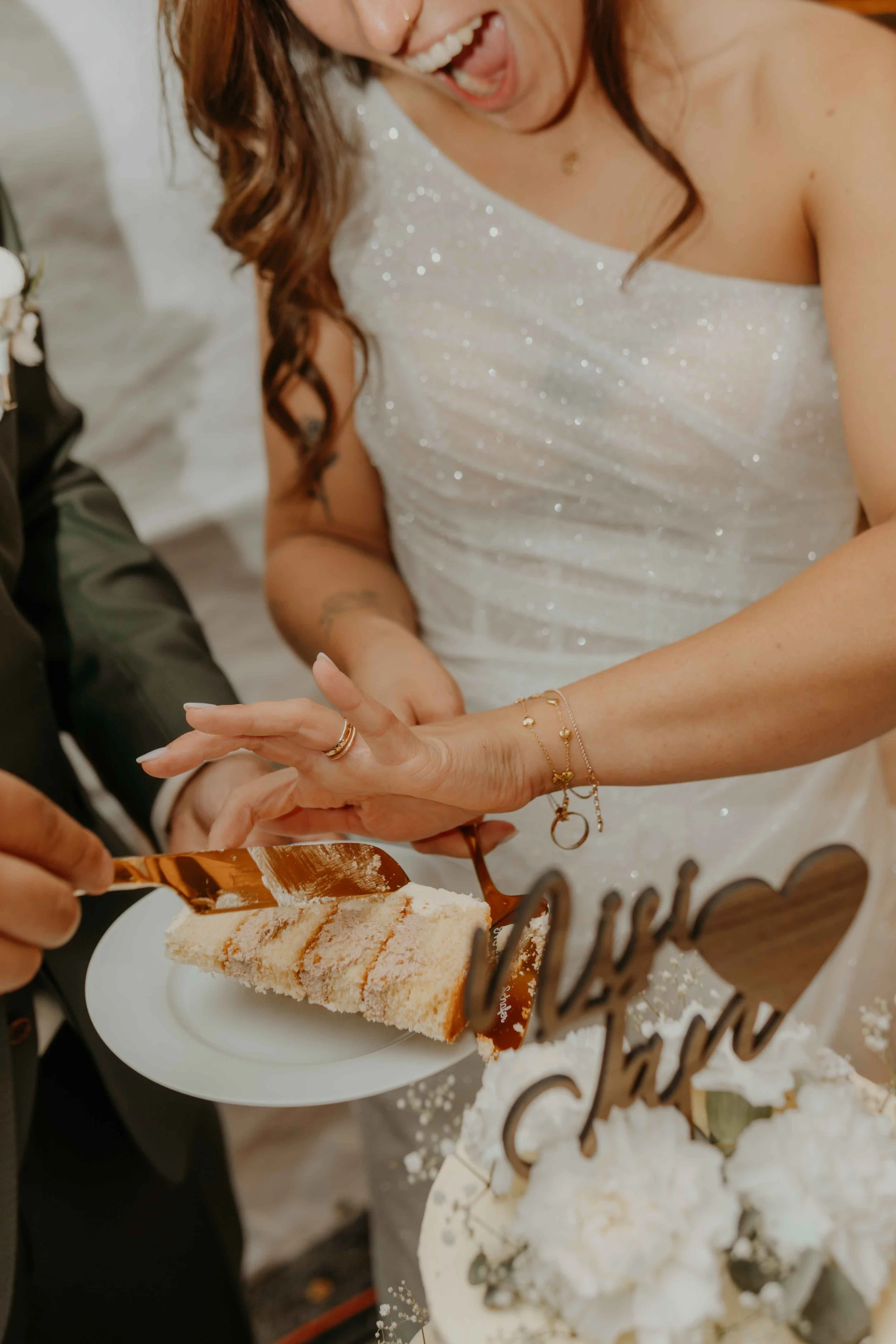 Echte, emotionale Hochzeitsfotografie – Brautpaar schneidet voller Leidenschaft die Hochzeitstorte an.