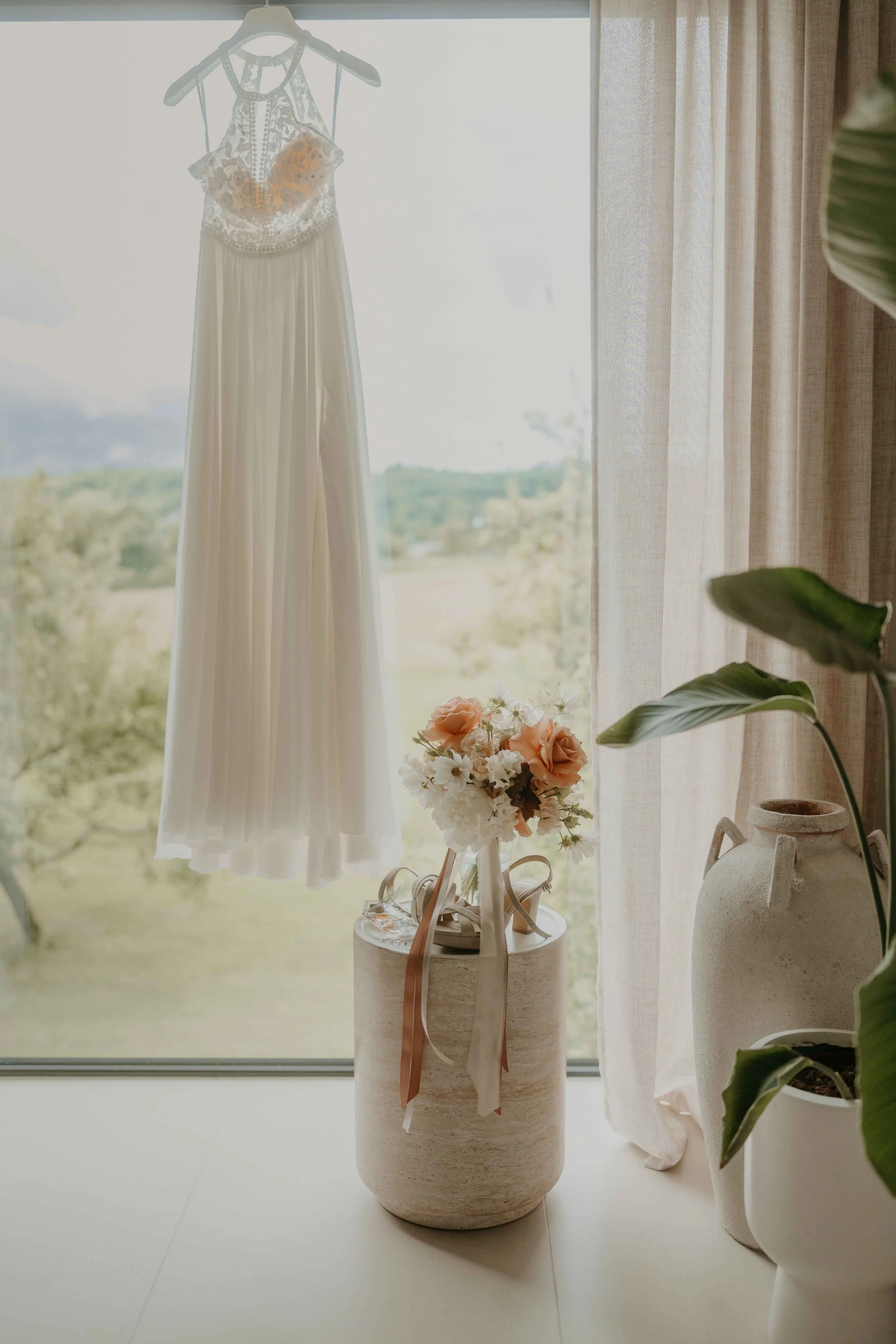 Detailfoto vom Brautkleid, hängend in der Suite auf Hof Reith, natürliche Hochzeitsfotografie.