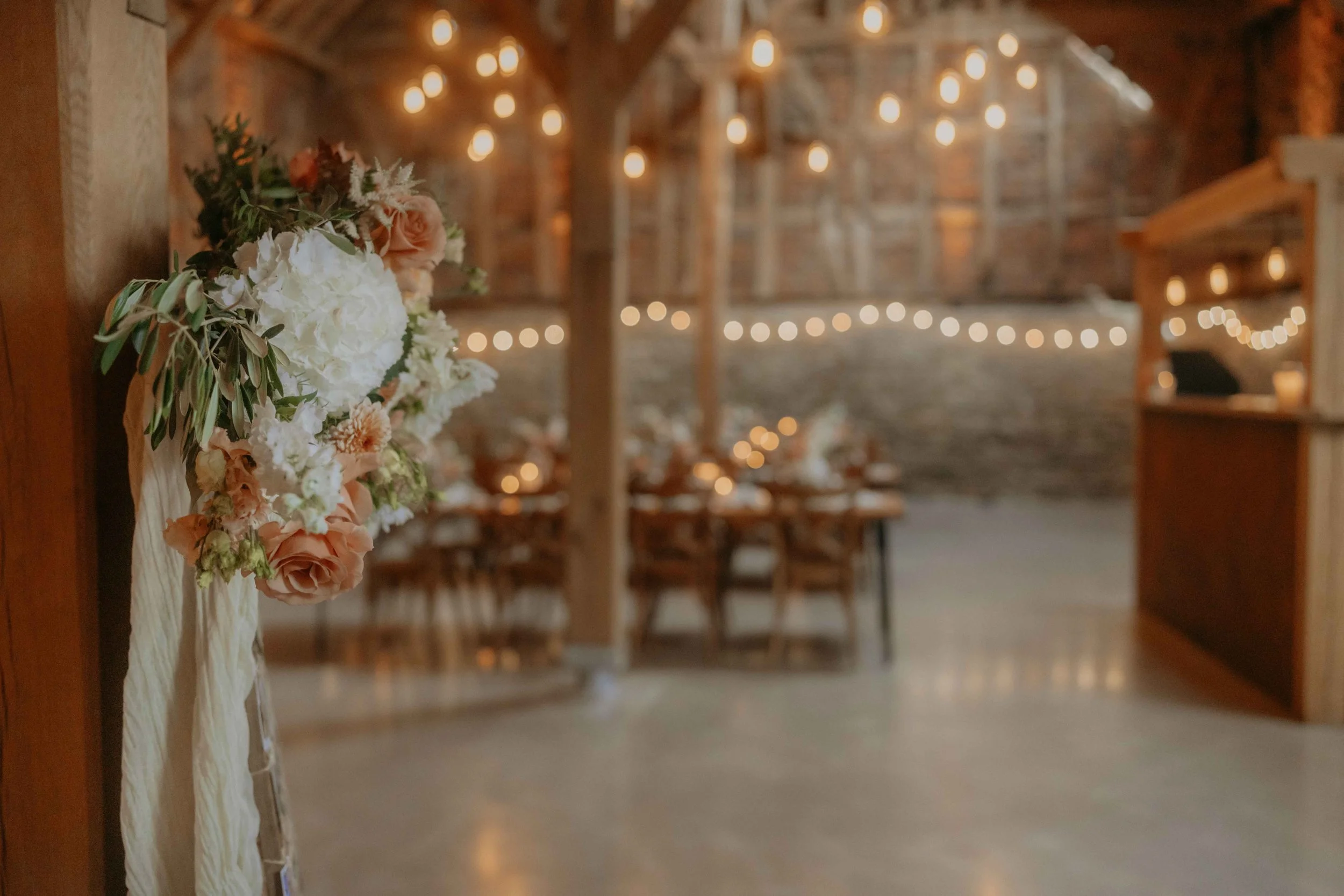 Festsaal in der Scheune auf Hof Reith, liebevoll gedeckte Tische und Lichterkette.