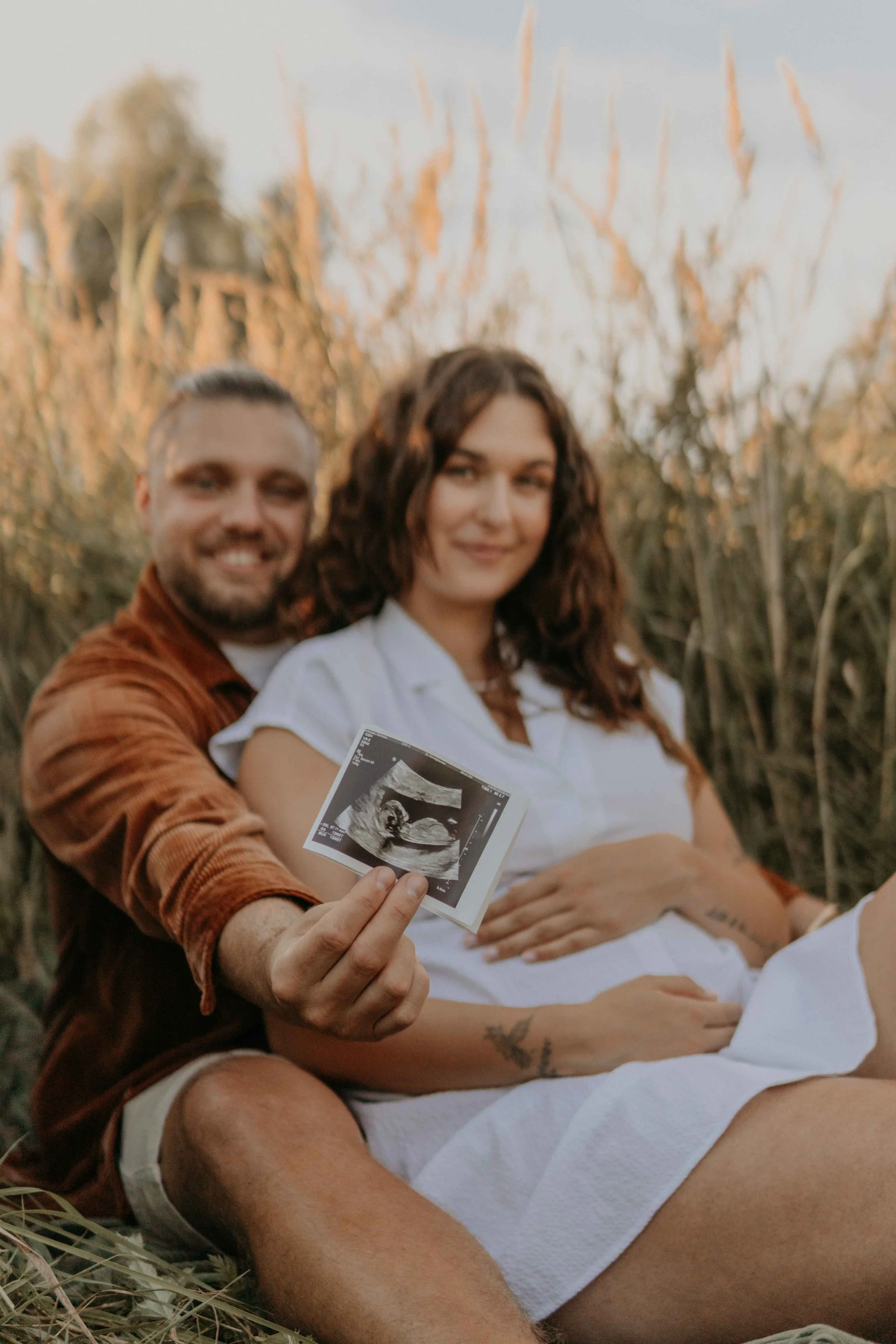 Babybauchshooting Hamburg – werdende Eltern halten Ultraschallbild in die Kamera von Jara Lenz.