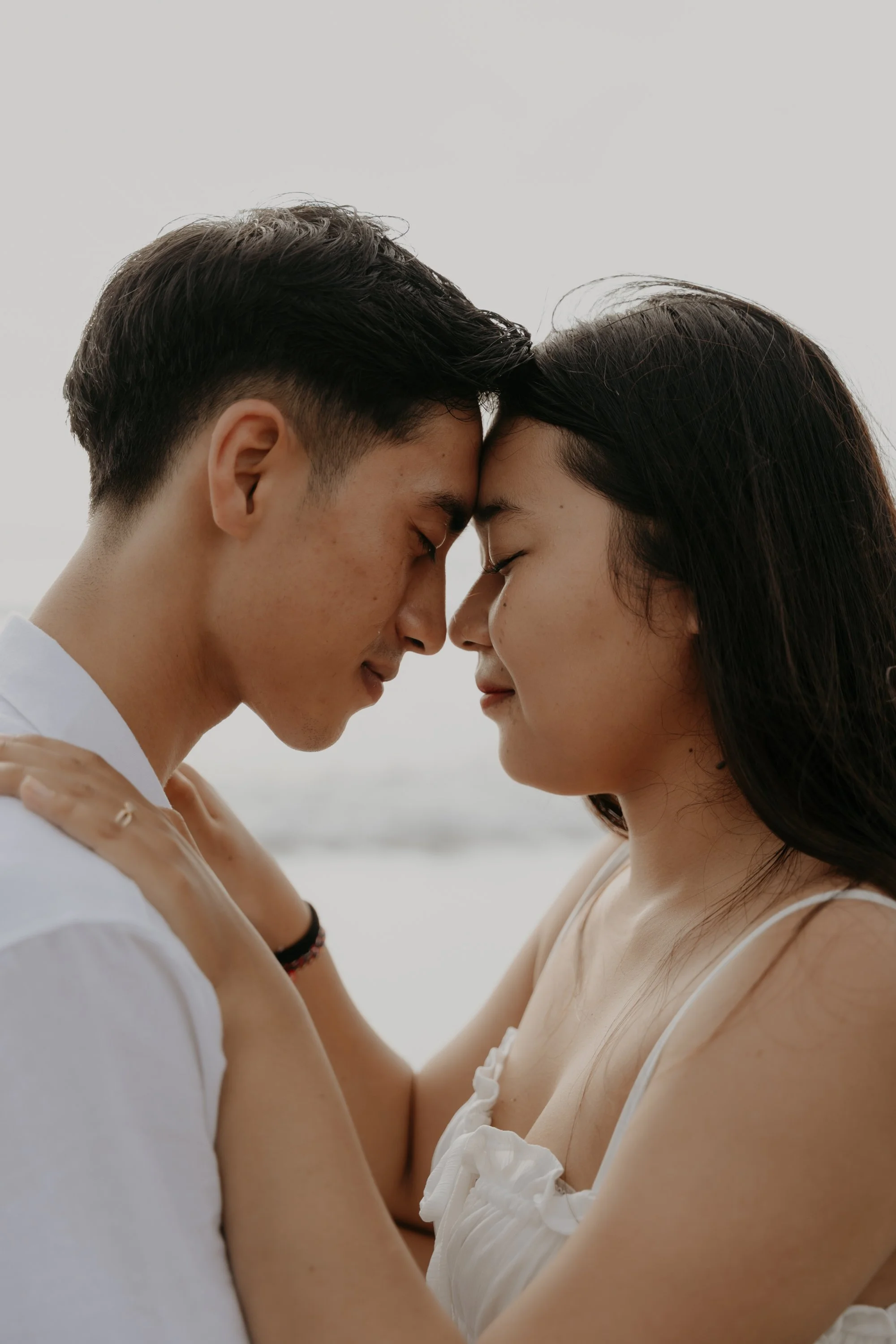 Intimate wedding in Bali – verliebter Blick des Paares mit Meer im Hintergrund.