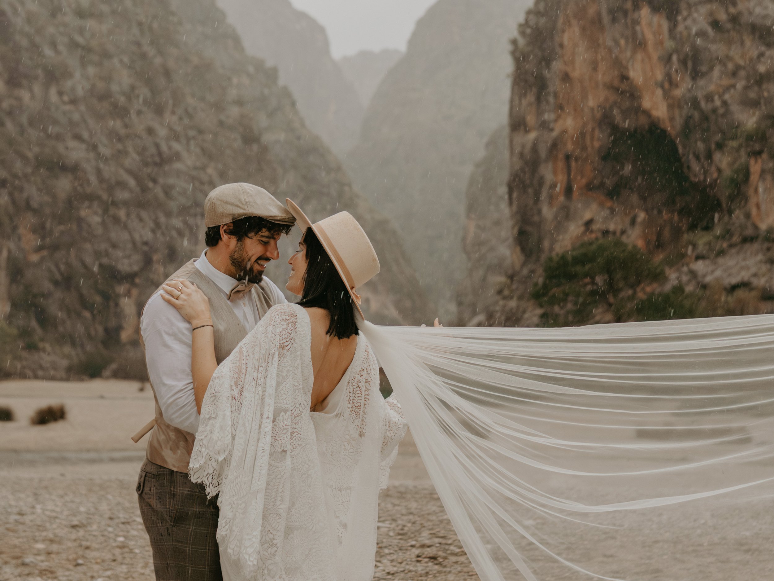 Elopement Storytelling – leiser Augenblick zwischen zwei Menschen umgeben von Natur, Regen prasselt hinab, freudige intime Momente auf Mallorca. 