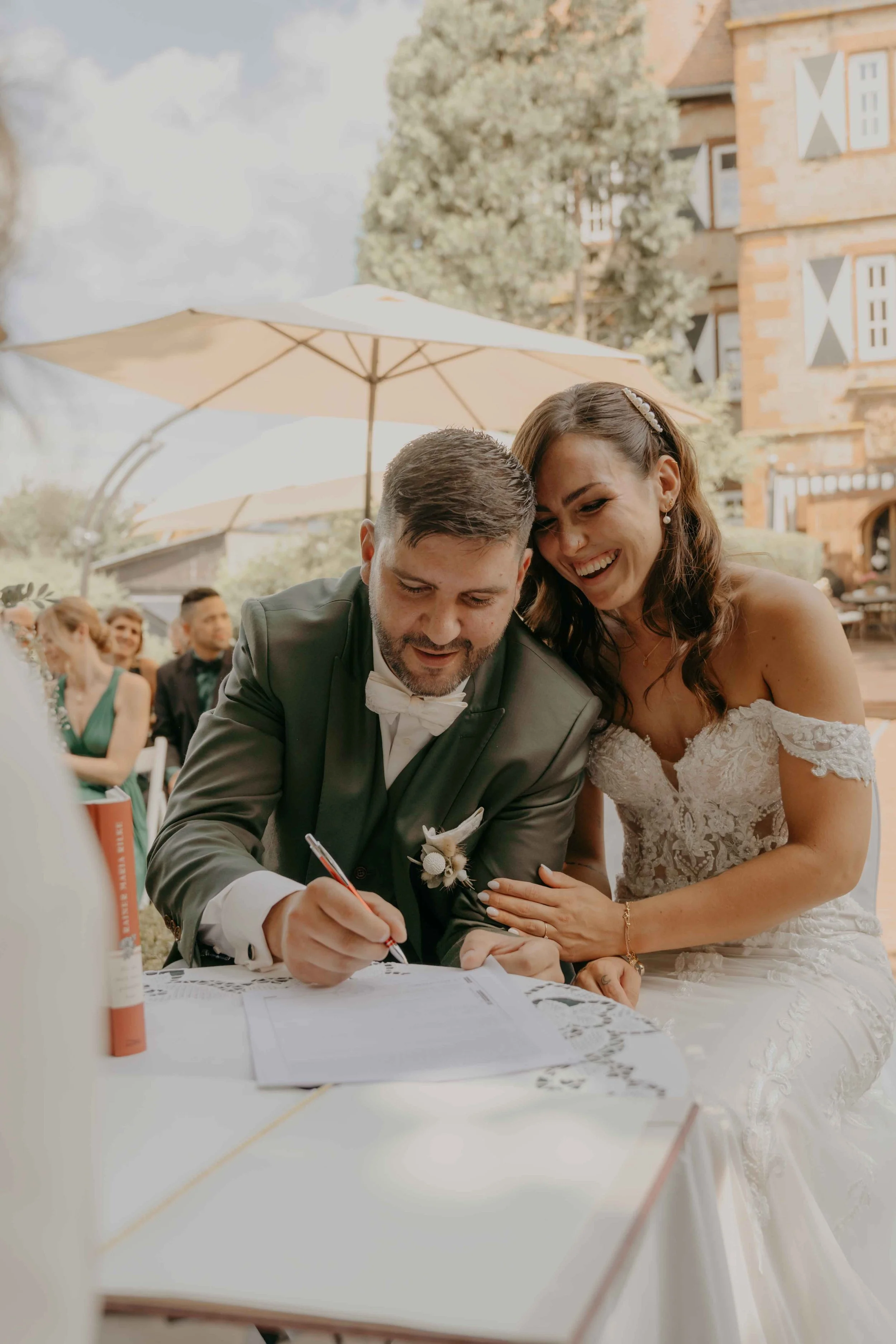 Elegante Schloss-Hochzeit in Deutschland – Brautpaar gibt sich das JA-Wort vor den Gästen und unterschreibt das Ehegelübte.