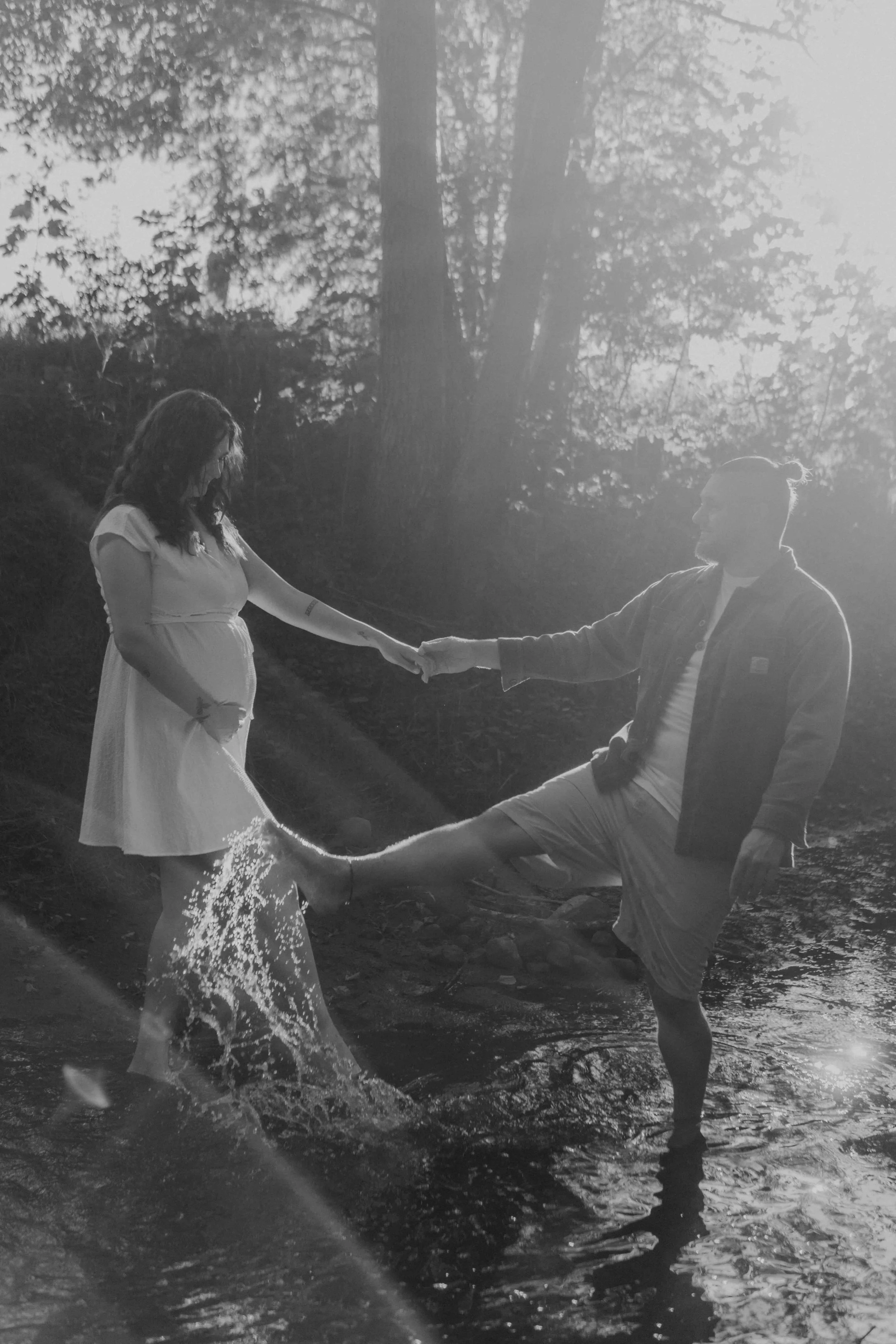 Maternety Shooting Hamburg – werdende Eltern toben im Bach mit dem Wasser. 