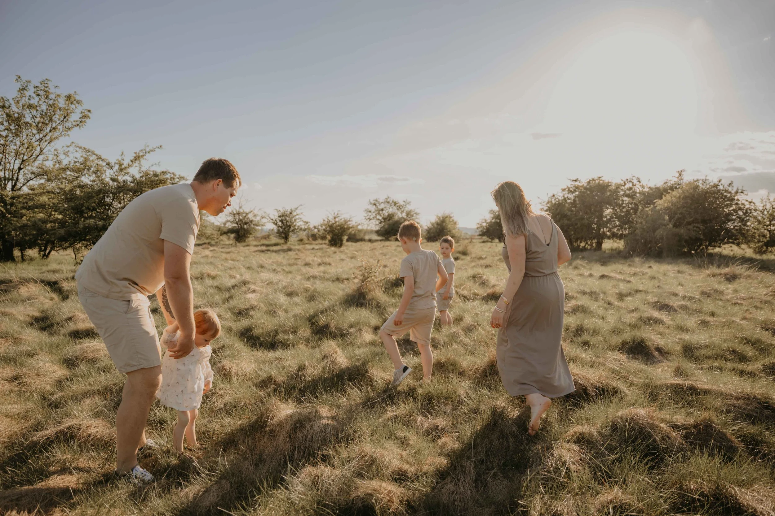 Familienfotografie Nordhessen – Familie tobt auf einer Wiese.