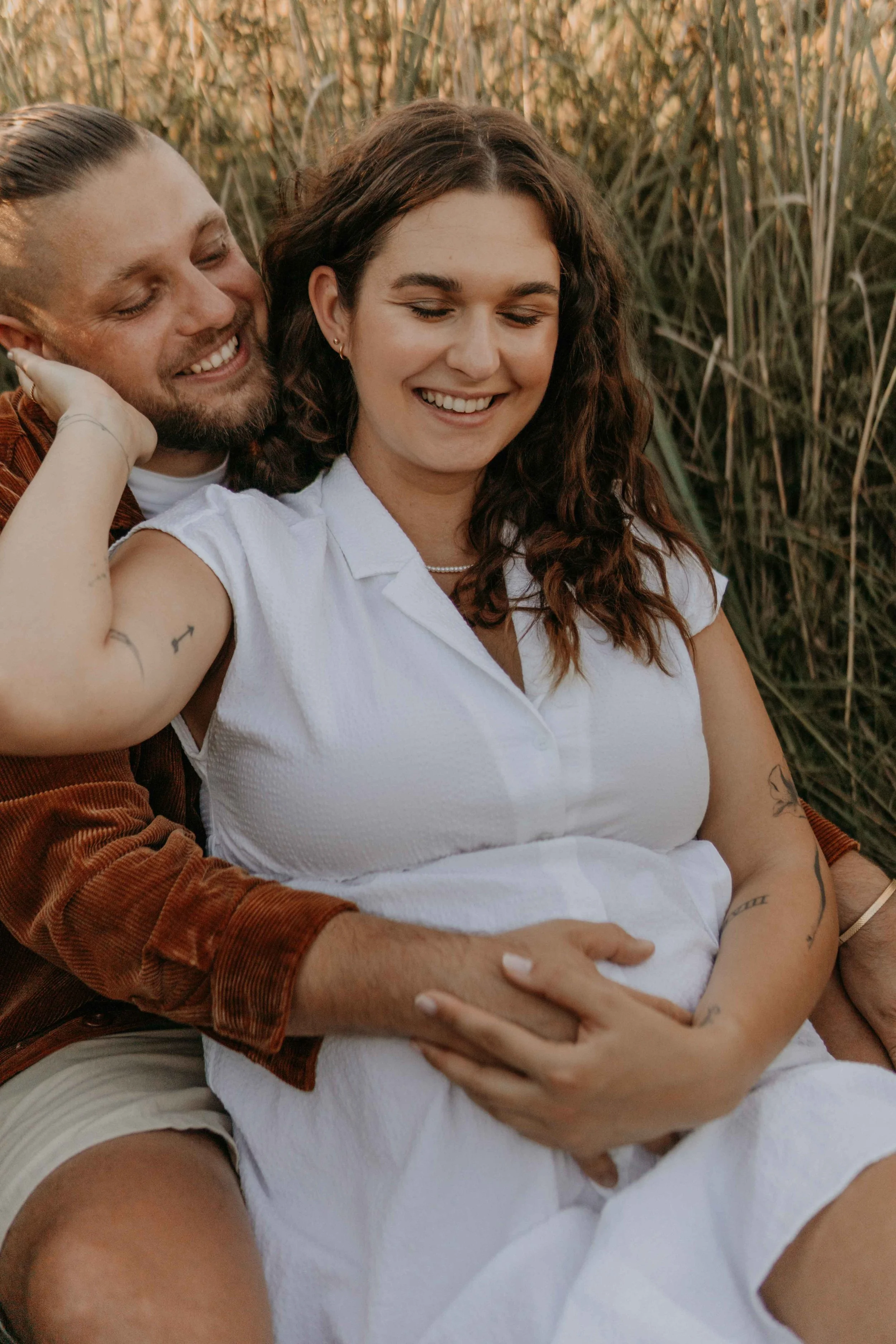 Maternety Shooting Hamburg –Pärchen hält den Babybauch fest und freut sich. 