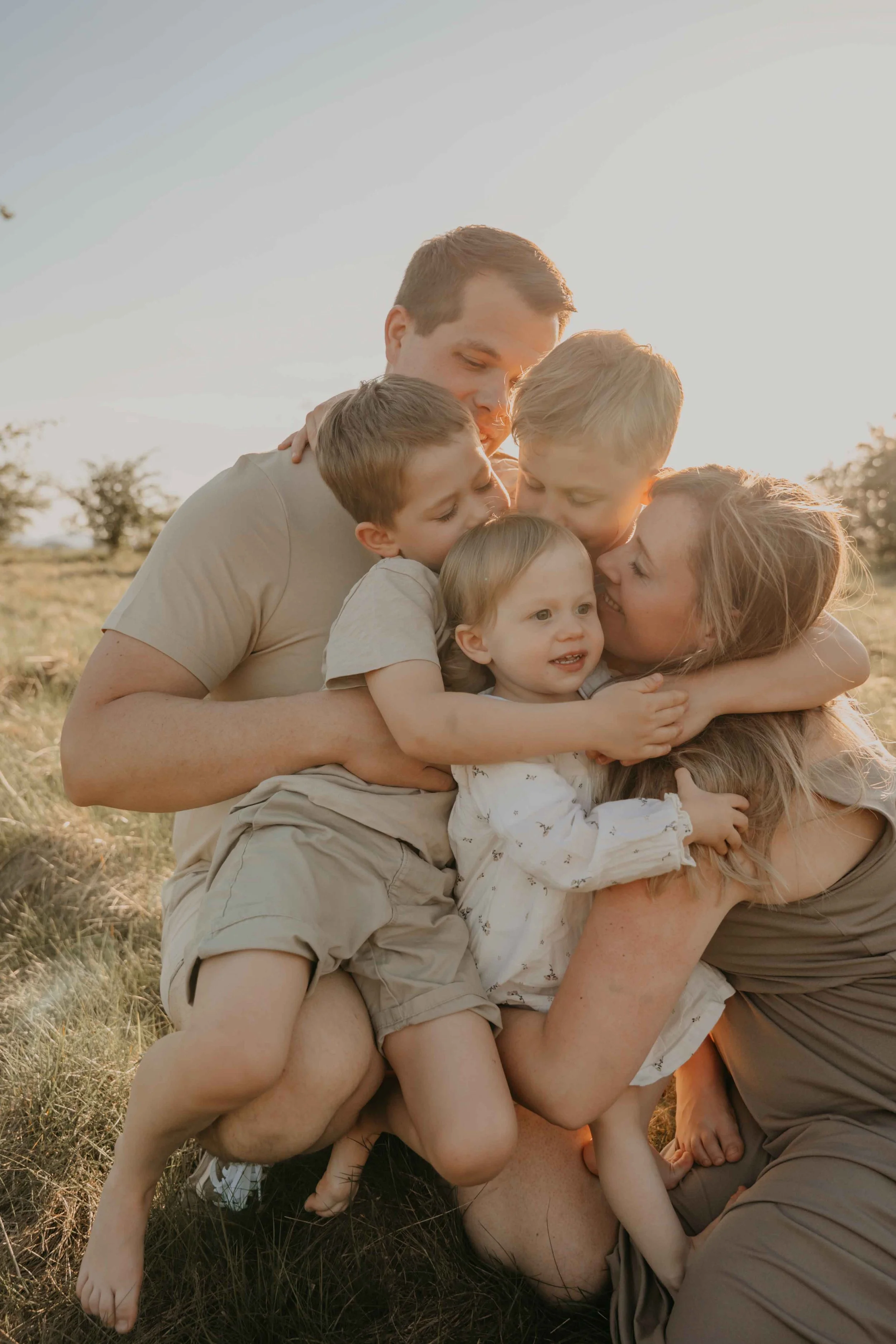 Familienfotografie Kassel – Eltern kuscheln mit ihren Kindern im Arm. Inniger Moment. 