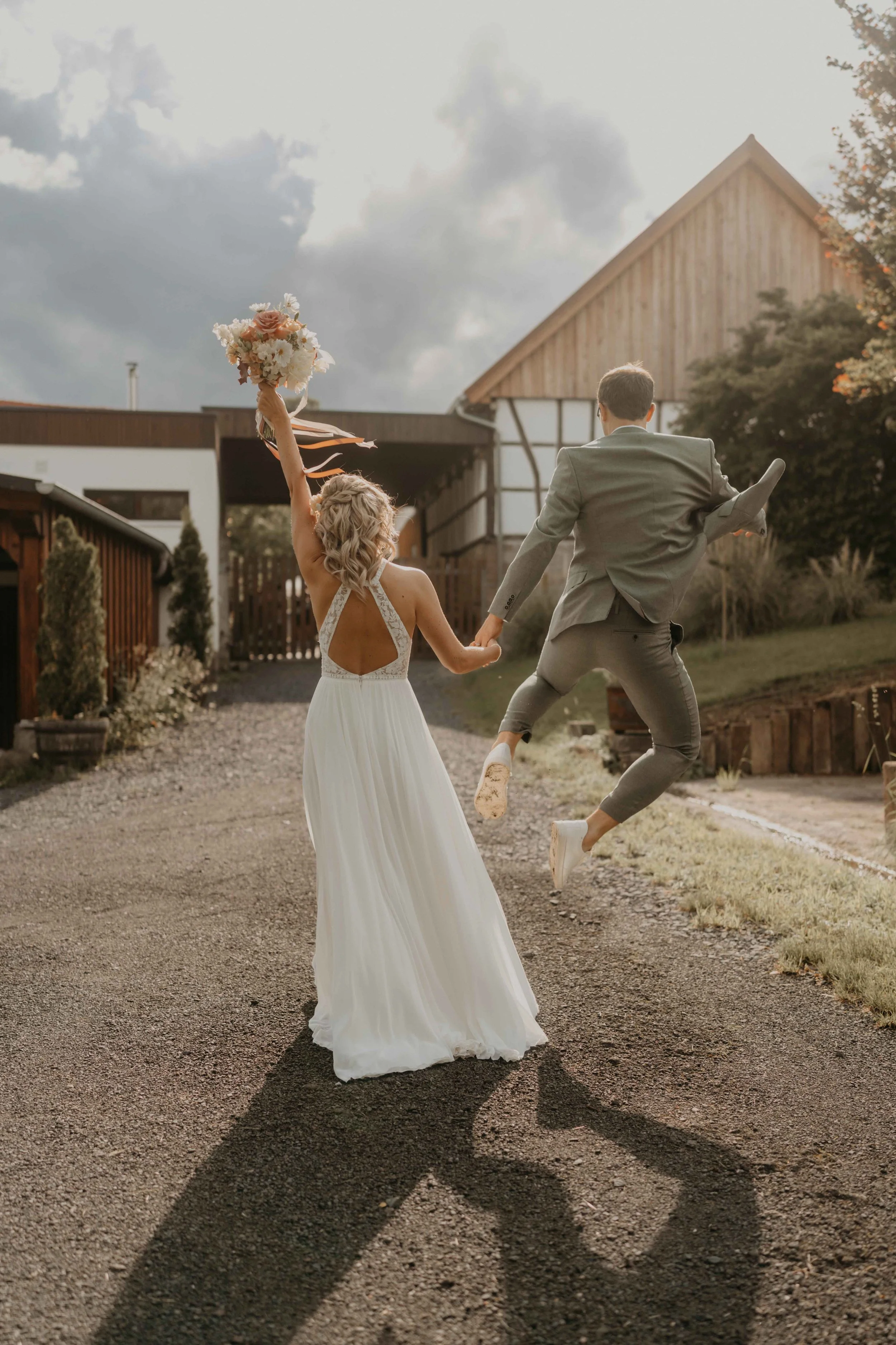 Hochzeitsfotografie Deutschland – Paar läuft Hand in Hand über eine Wiese in Nordhessen.
