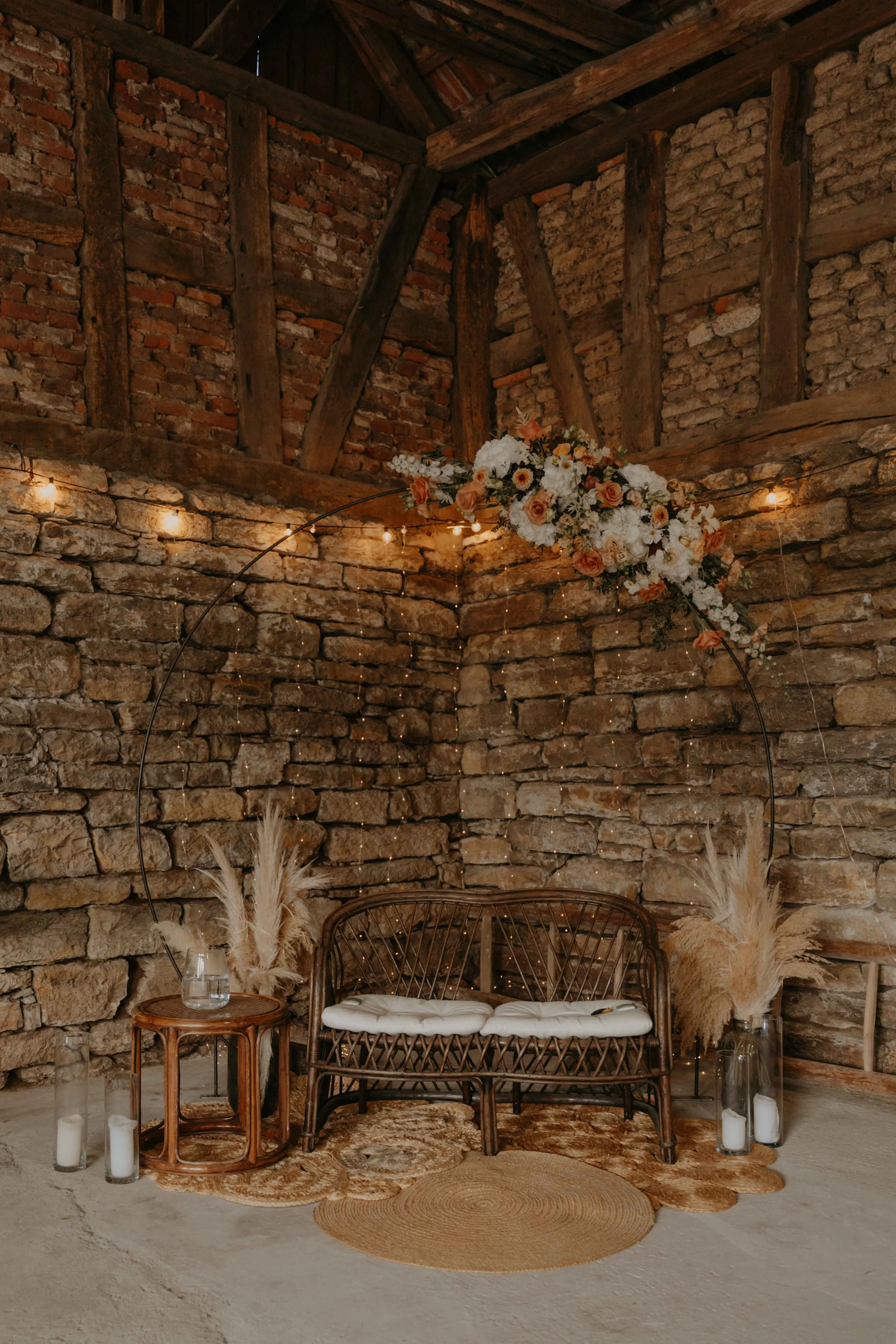 Dekoration der freien Trauung in der Scheune, Blumenbogen und Stühle in Reihen.