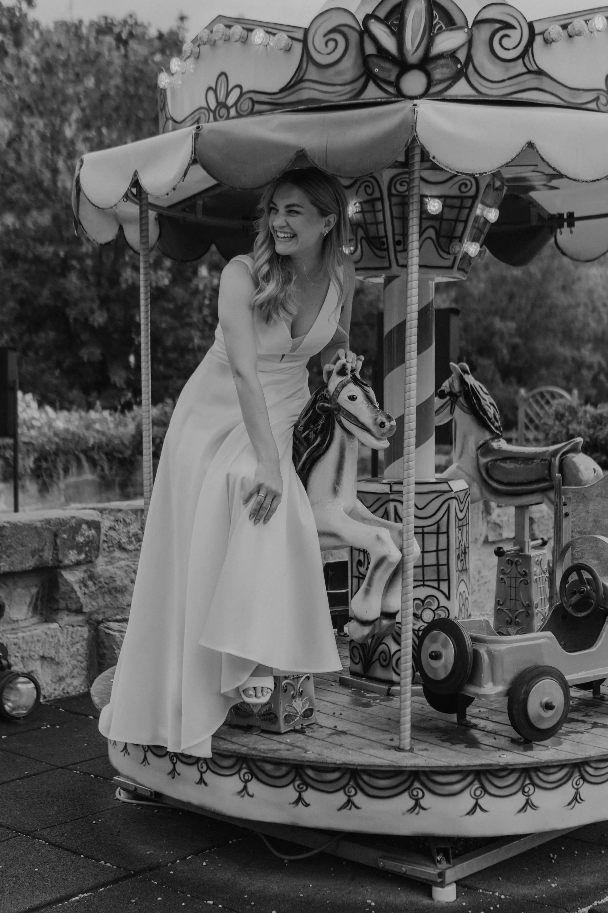 Hochzeitsreportage Walkemühle in Frankenberg, Nordhessen – Braut und Bräutigam im Innenhof, spielend auf dem Karussell.