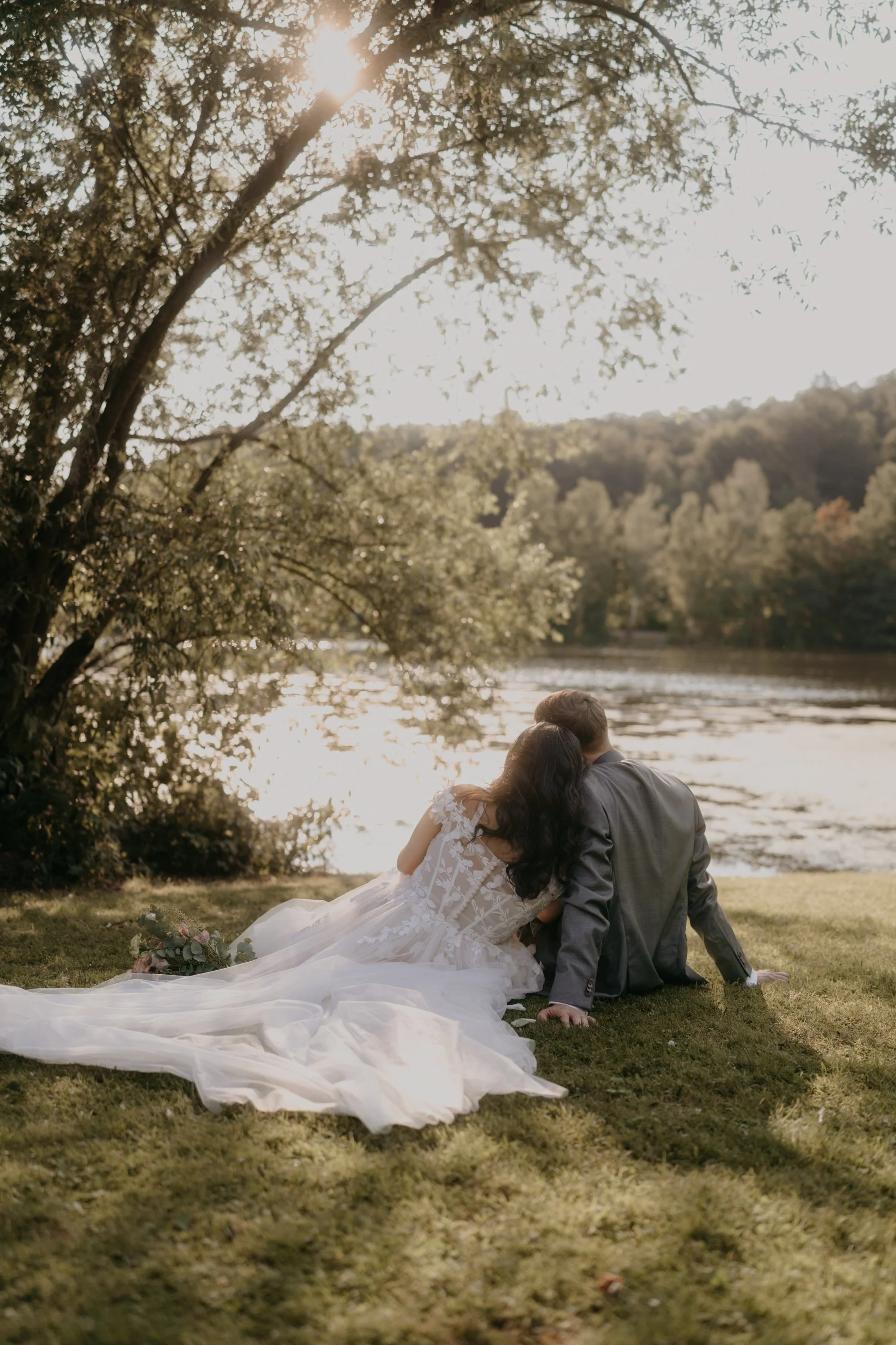 Brautpaar lehnt aneinander am Wasser im Gegenlicht – Hochzeitsfotografie auf Gut Kragenhof, Kassel, Hessen
