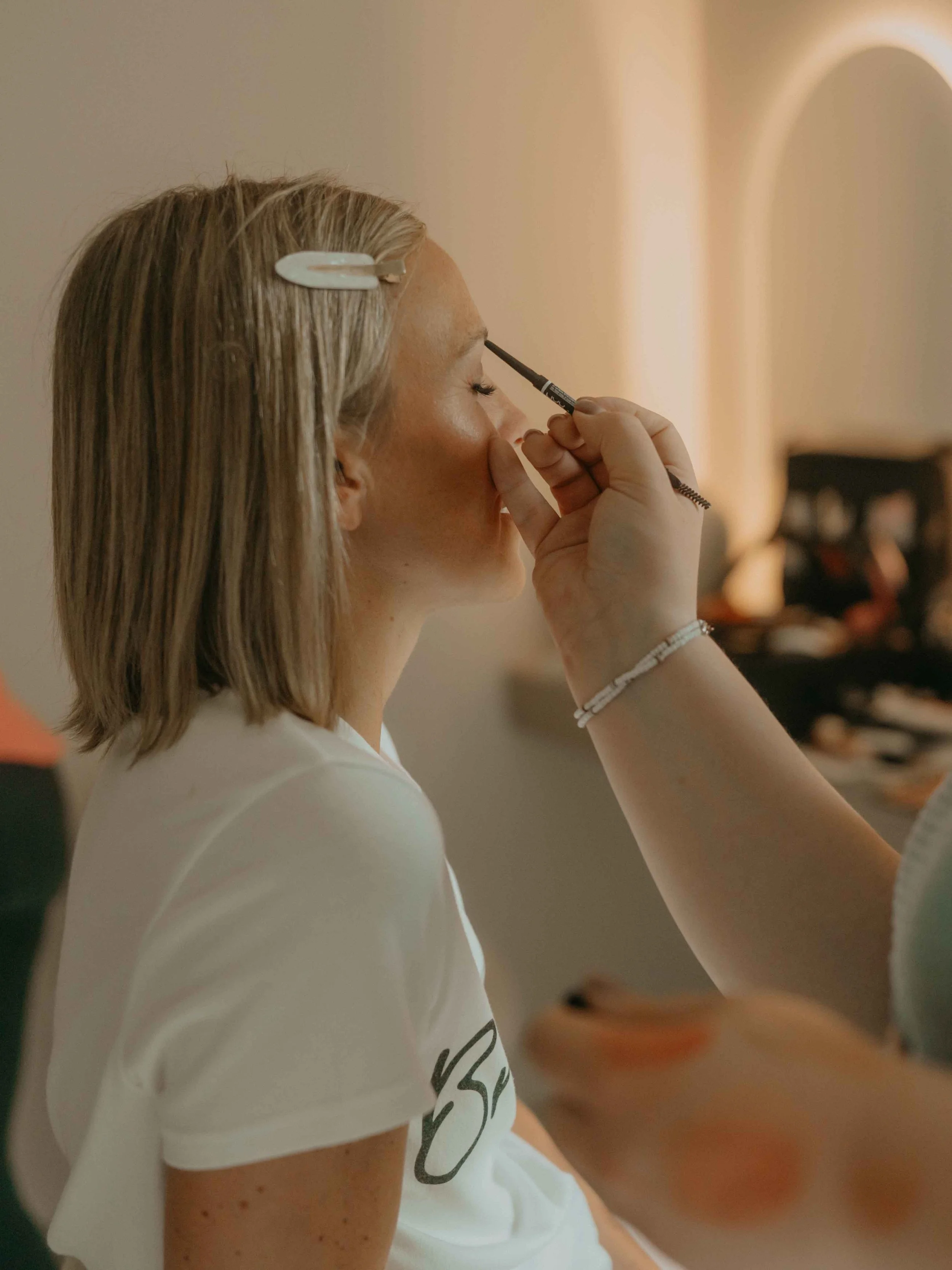 Braut schminkt sich in der Hof Suite, Getting Ready Moment voller Vorfreude.