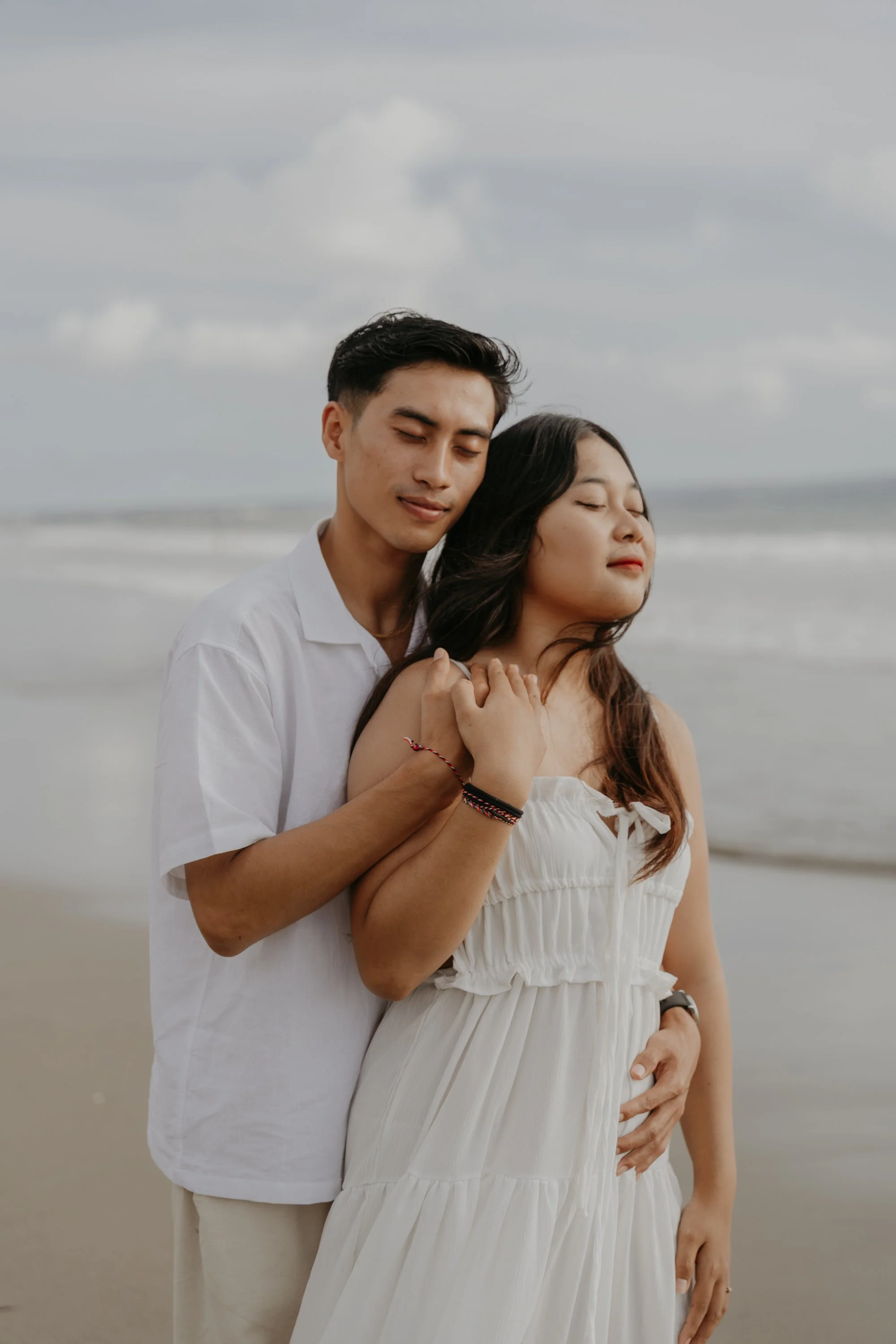 Intimate wedding in Bali – verliebter Blick des Paares mit Meer im Hintergrund.