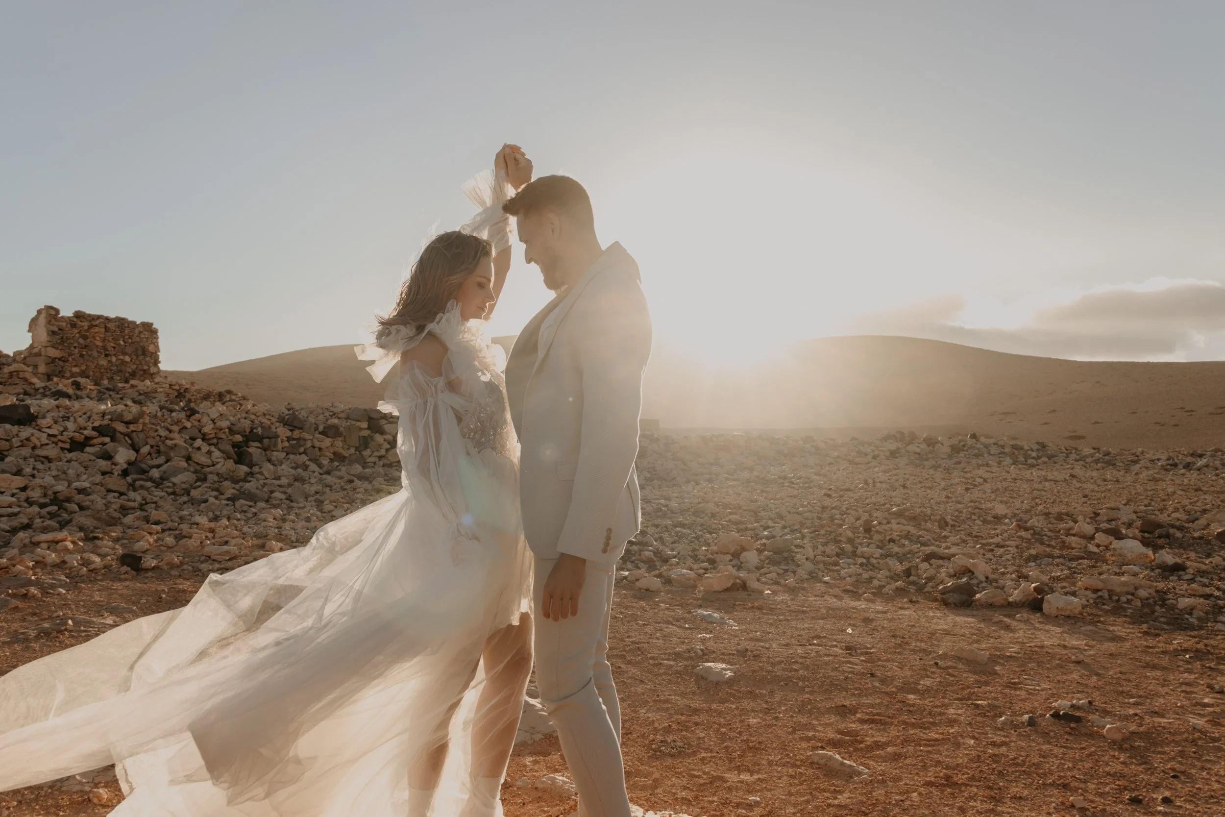 Wedding Abroad – Brautpaar tanzt im Licht des Sonnenuntergangs in der Wüste von Fuerteventura, Spain. 