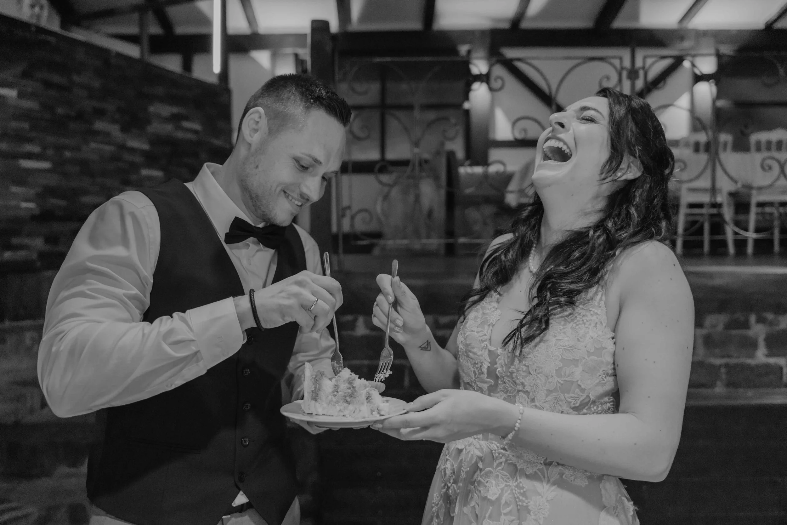 Hochzeit auf Schloss Eicherhof in Leichlingen – Brautpaar schneidet ausgelassen die Torte an und hat viel Spaß.