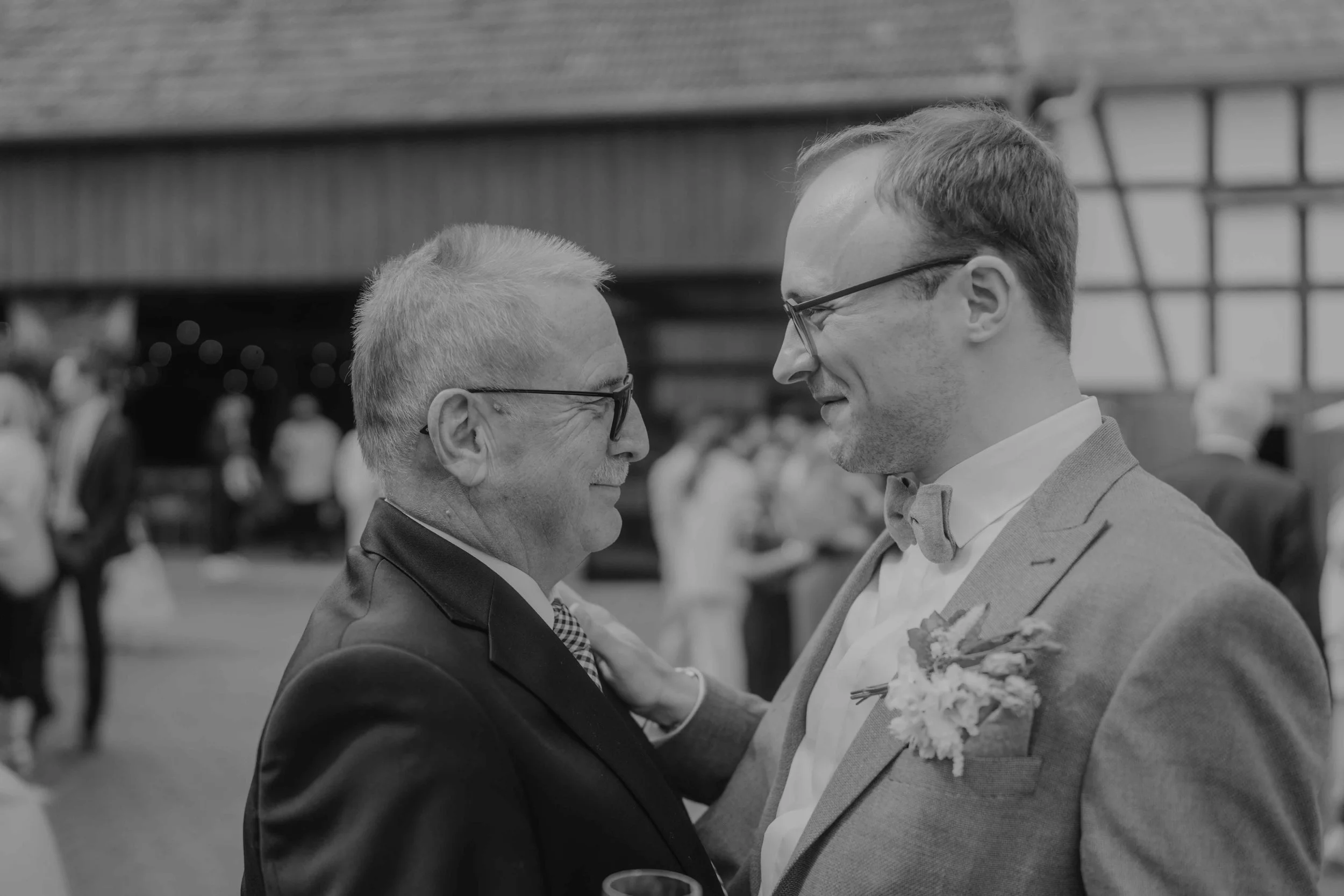 Braut und Bräutigam im Gespräch mit Gästen beim Sektempfang am Hof Café.