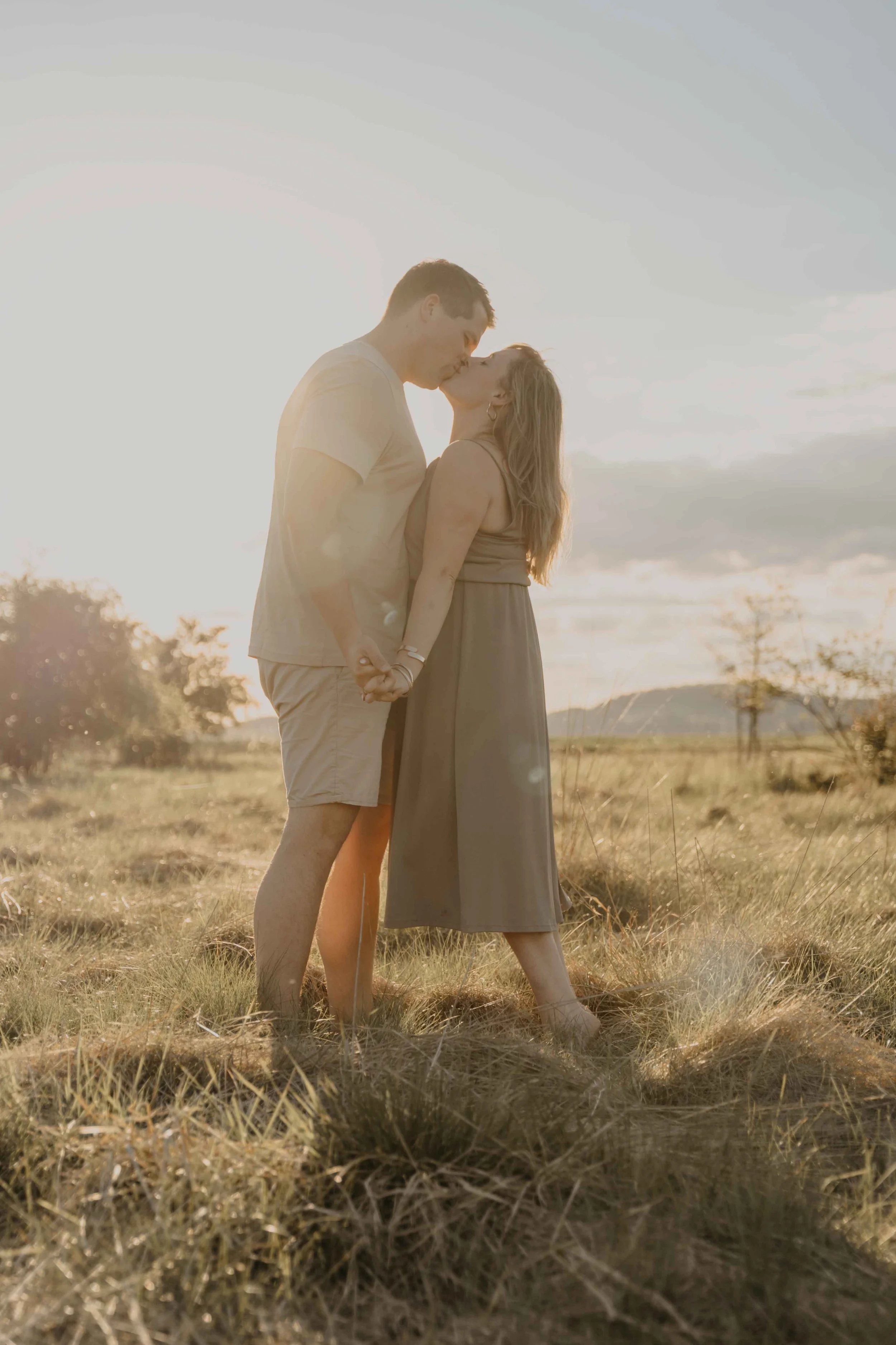 Authentische Familienfotografie Waldeck-Frankenberg – Paar küsst sich im Sonnenuntergang.